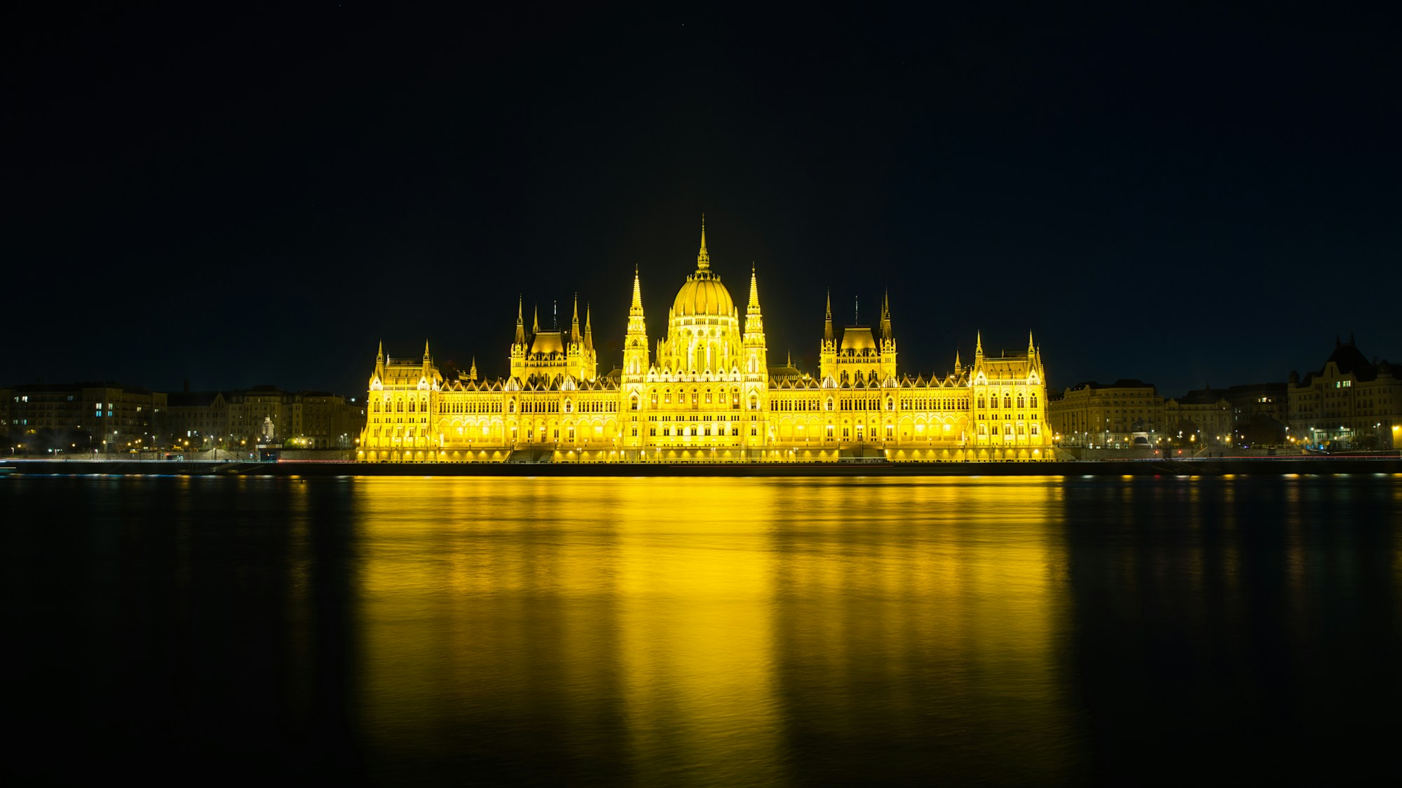 Vista notturna del Parlamento di Budapest illuminato, riflesso nel Danubio — capitale ungherese