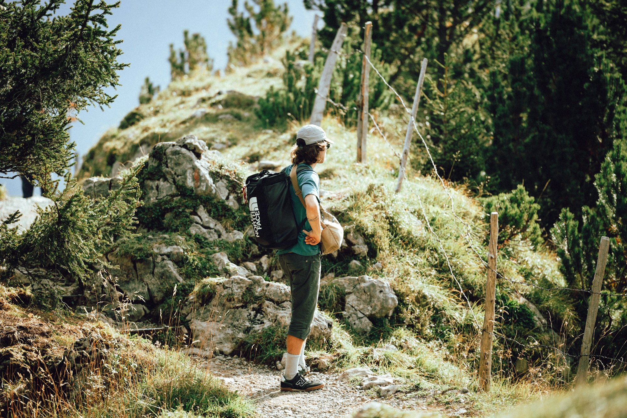 Randonneur avec sac à dos sur un sentier rocailleux sous la lumière alpine