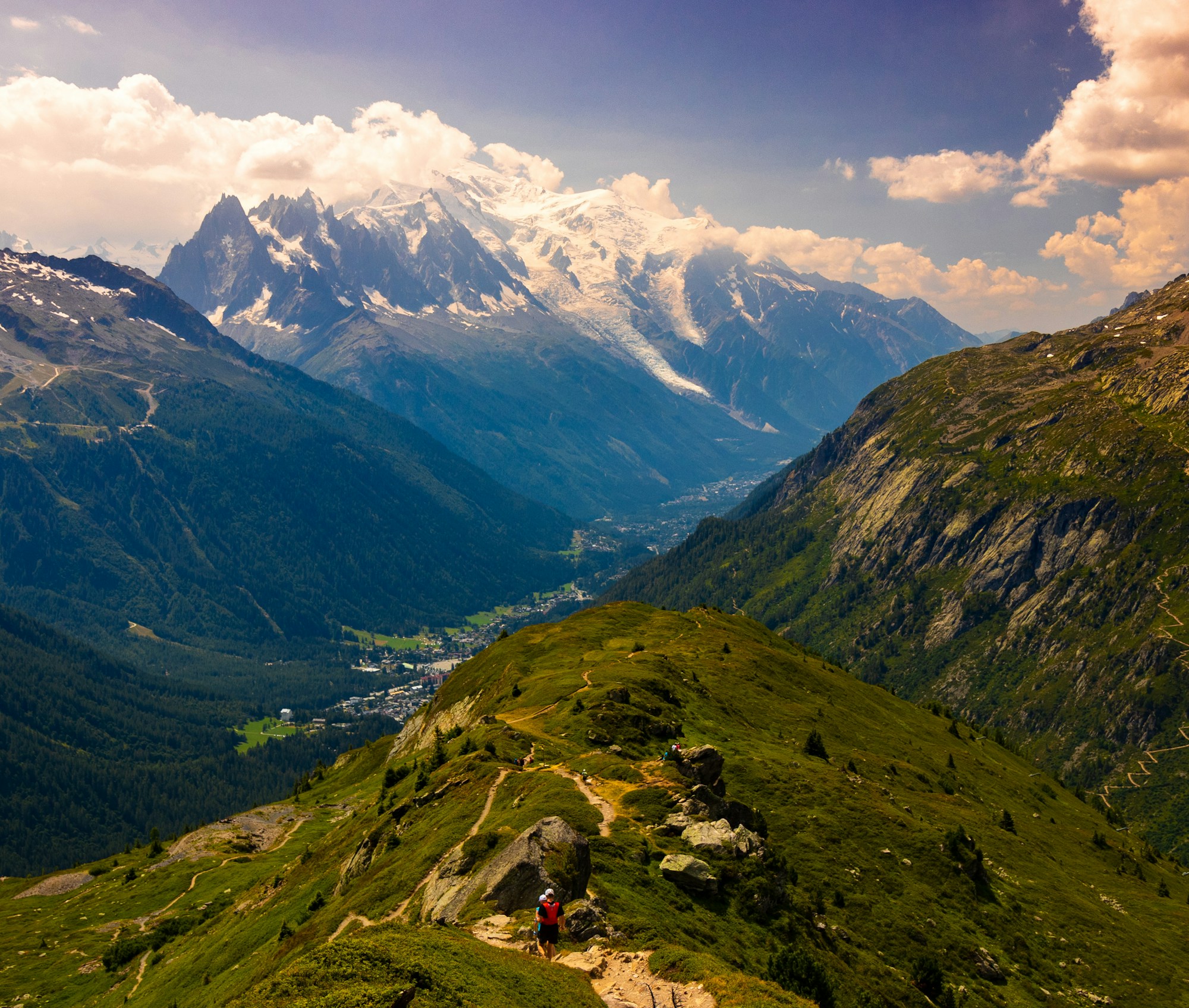 Randonneurs sur le sentier du Tour du Mont-Blanc avec vue sur le massif enneigé