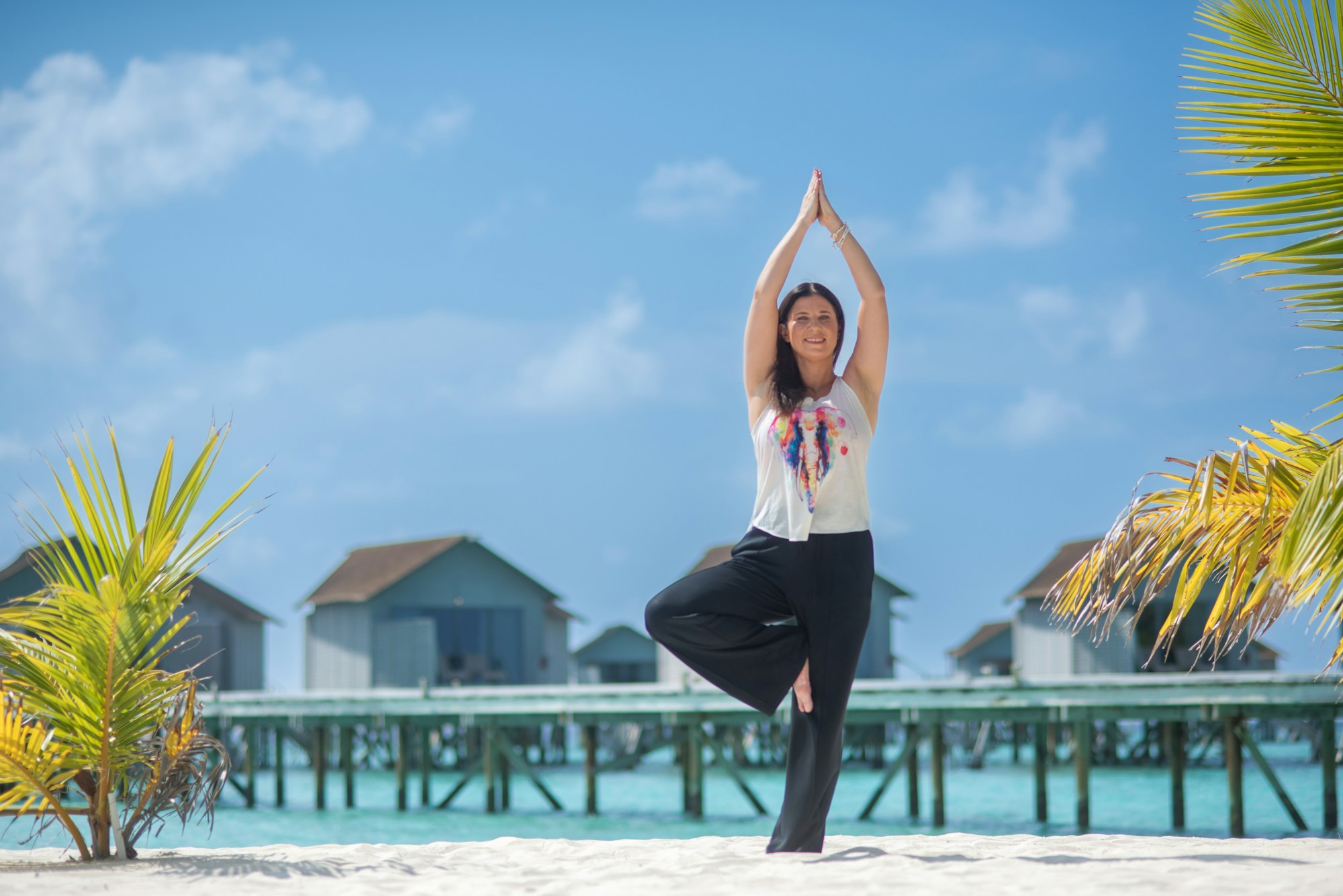 Woman practicing yoga facing a natural landscape