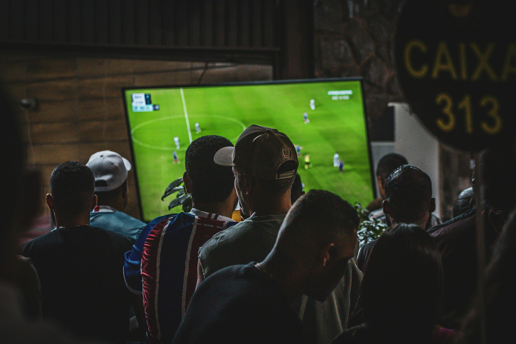 Group of people watching a football match in a pub