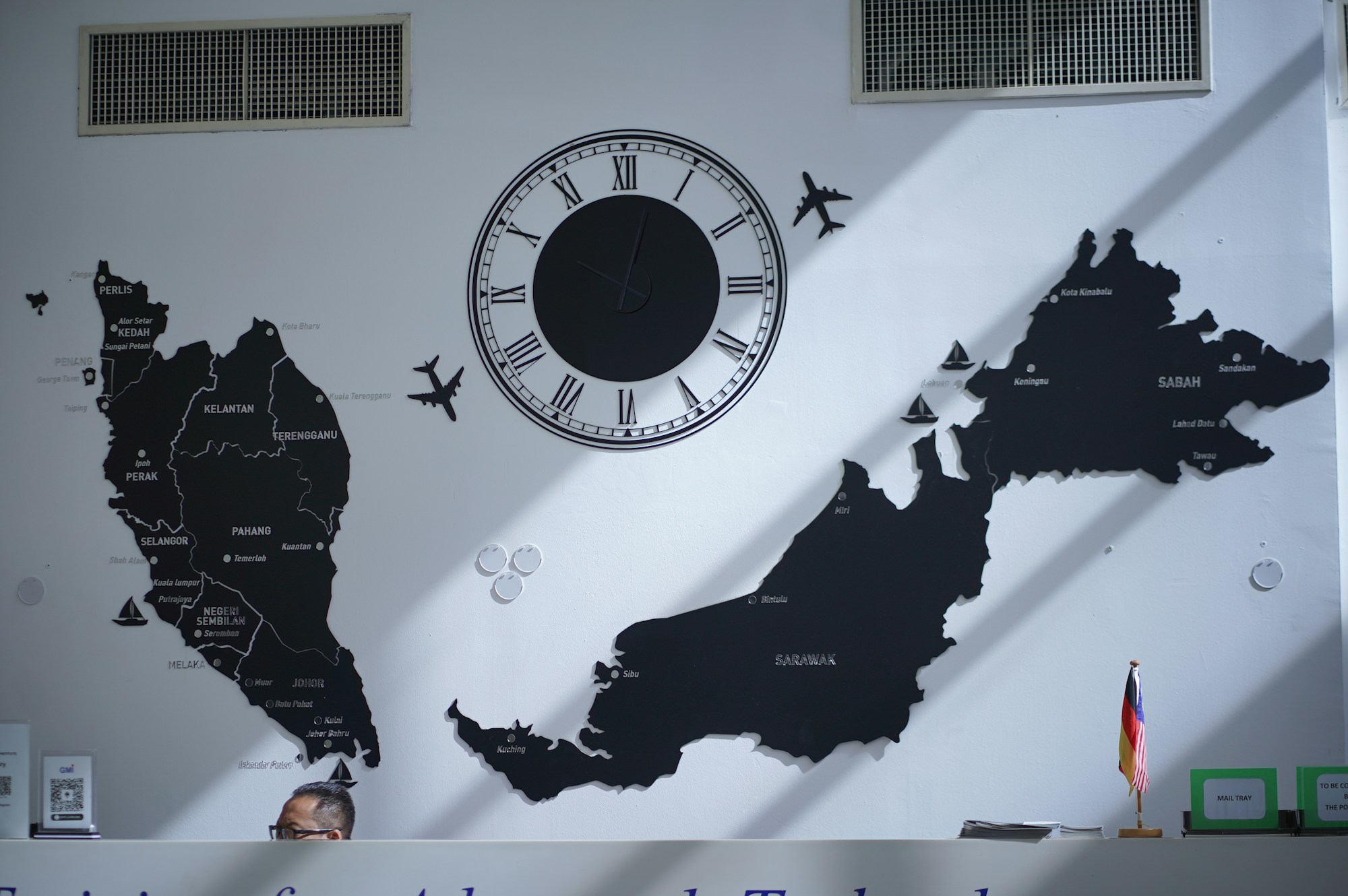 Mur décoré avec une carte du monde, une horloge et des avions miniatures