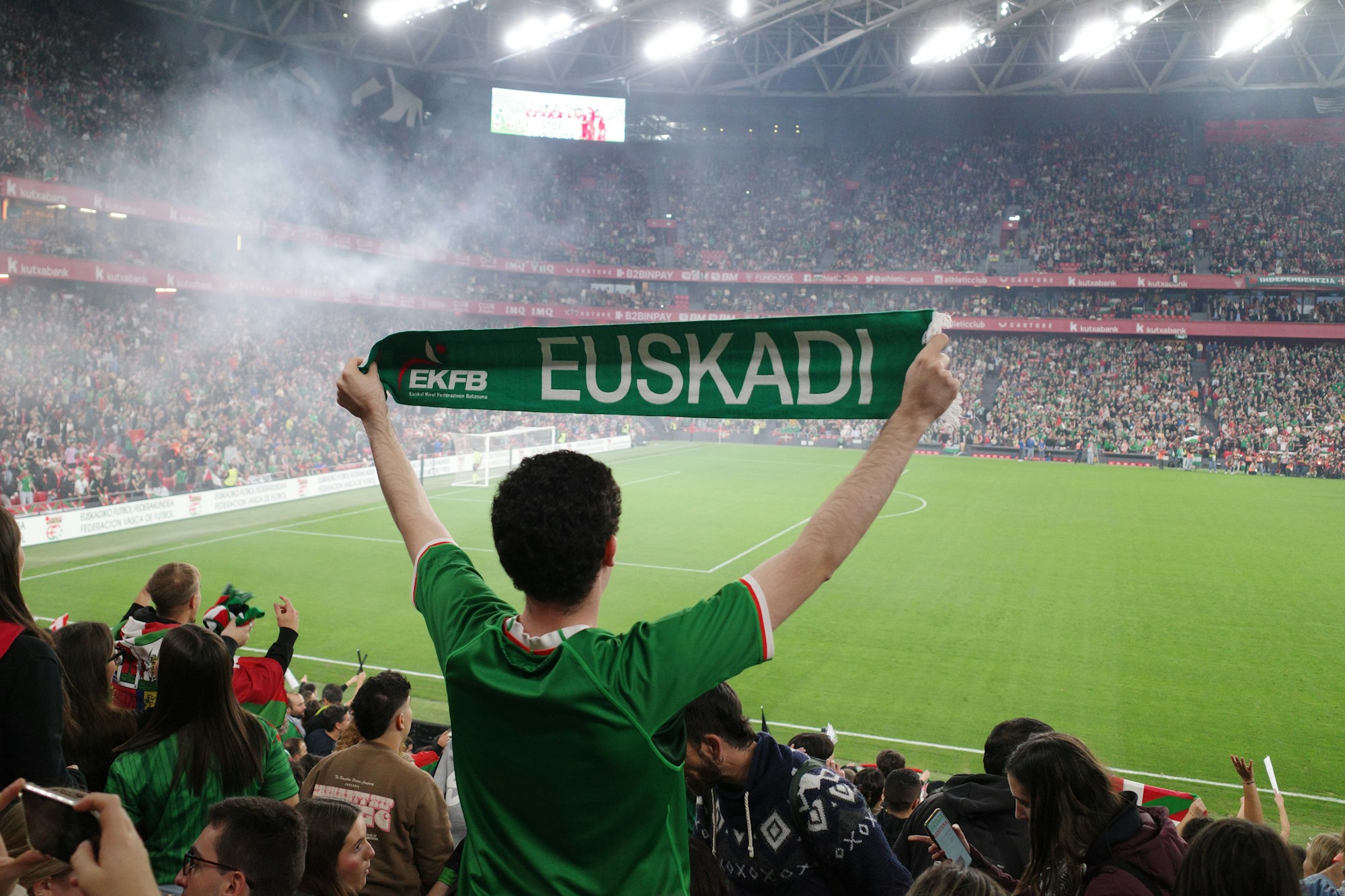 Football supporters celebrating in a lively fan zone atmosphere