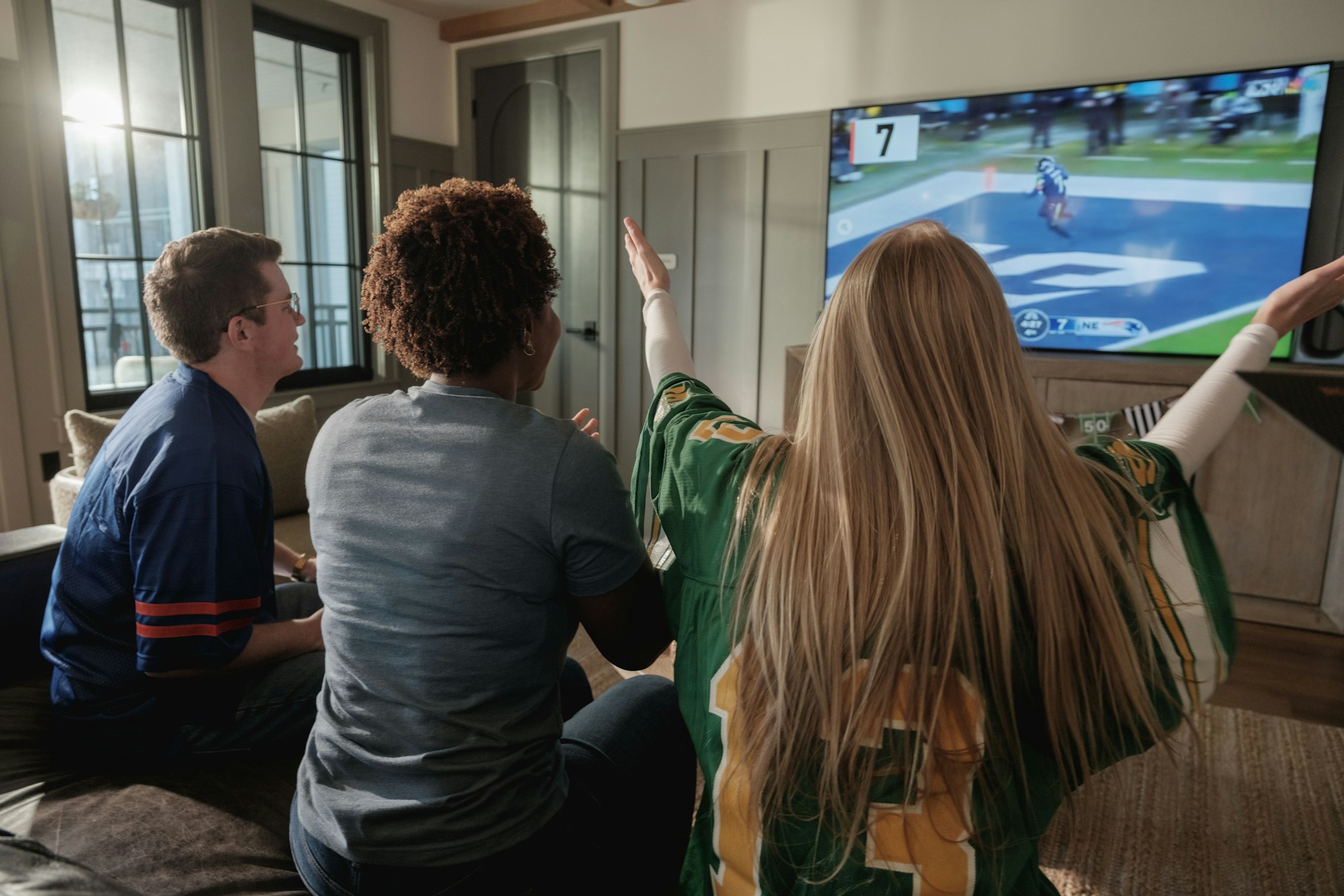 Amis regardant un match de sport à la télévision ensemble