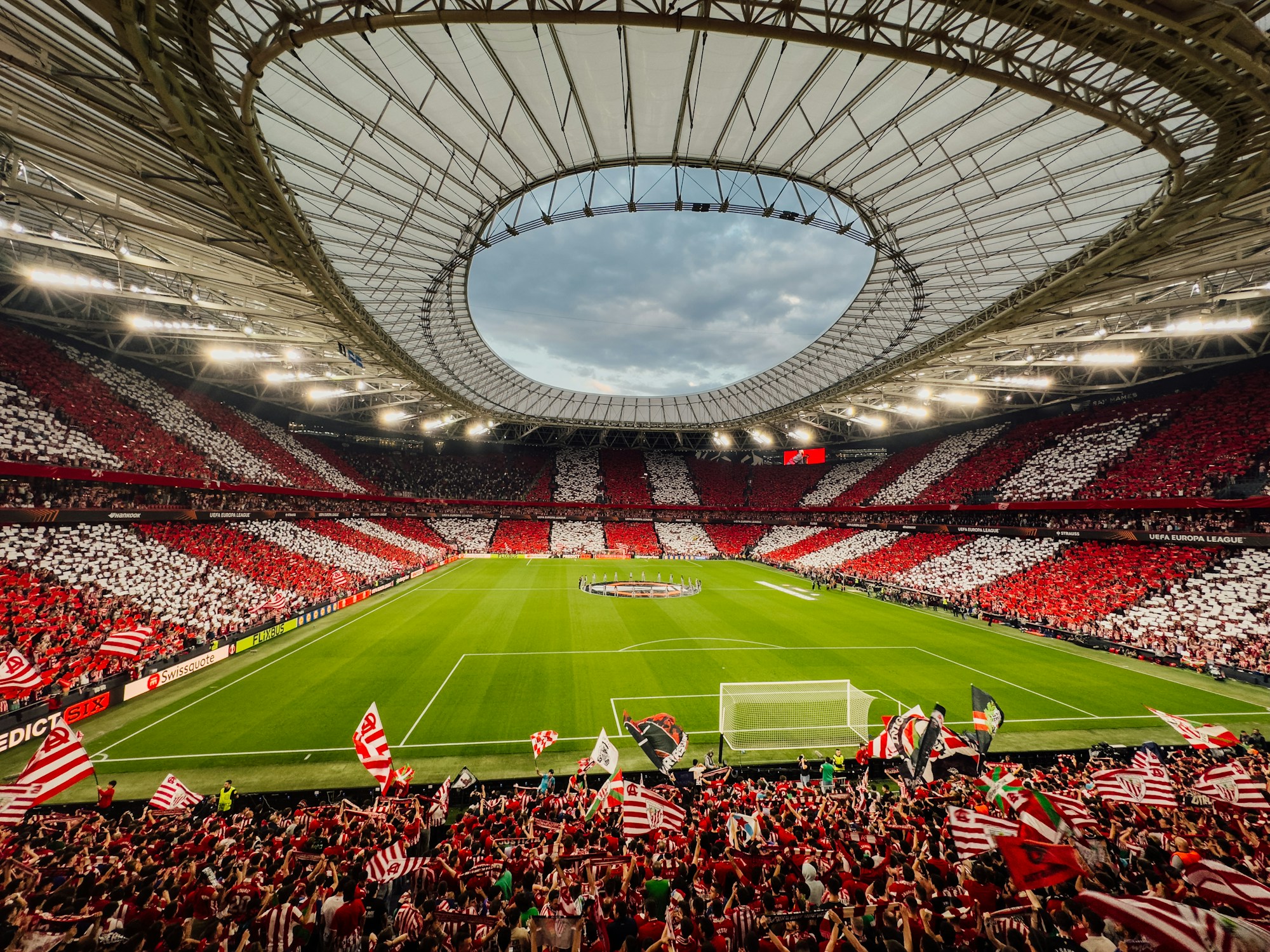 Stade rempli de supporters en rouge et blanc encourageant leur équipe