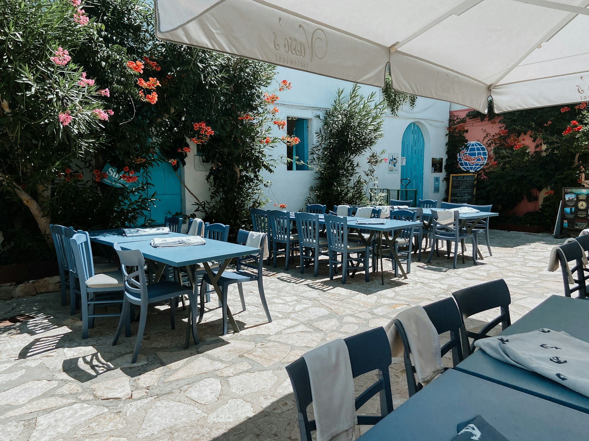 Terrasse d'une taverne traditionnelle grecque avec tables et chaises en plein air