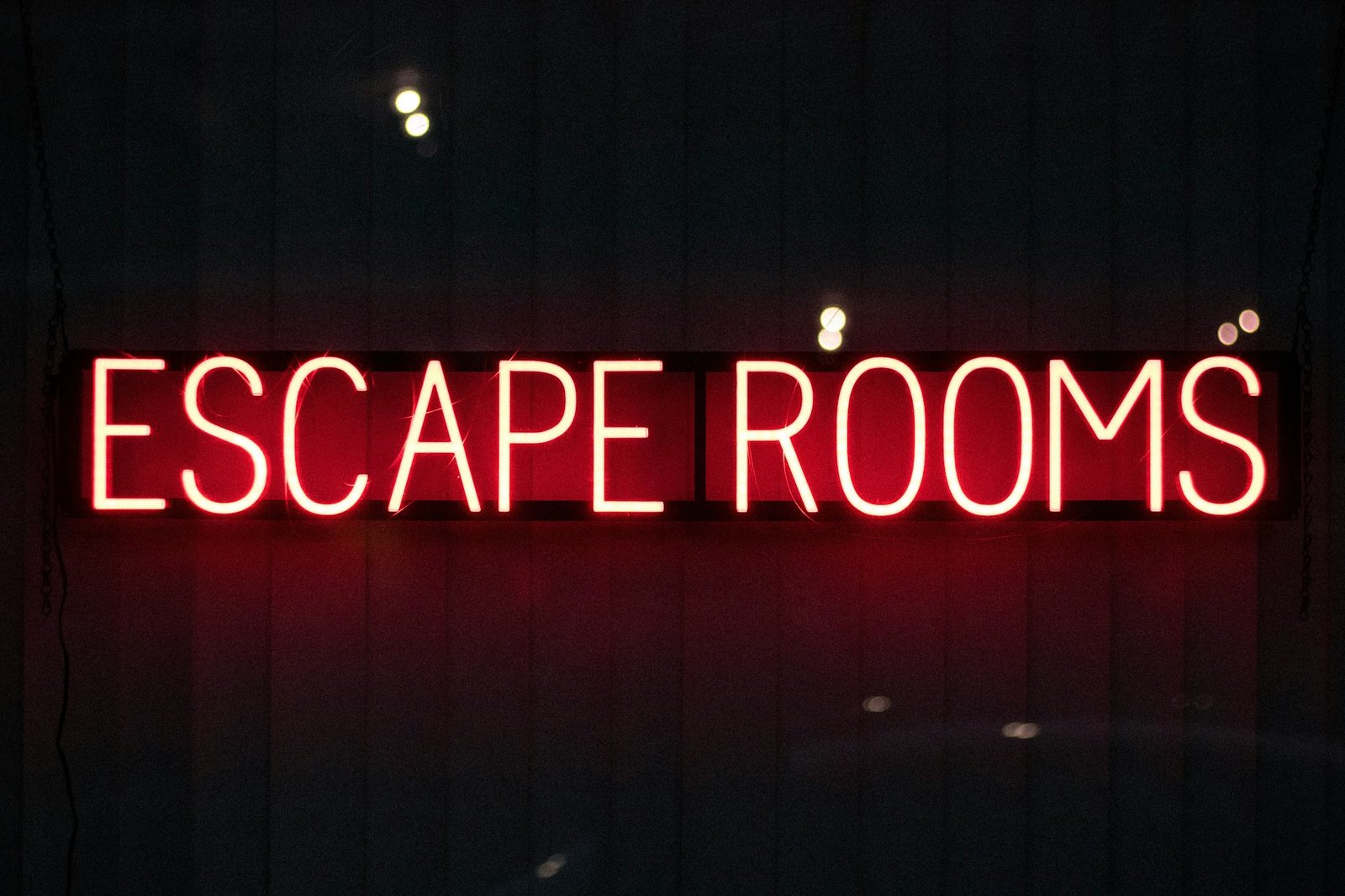 Enseigne lumineuse rouge escape rooms — symbole du théâtre immersif moderne