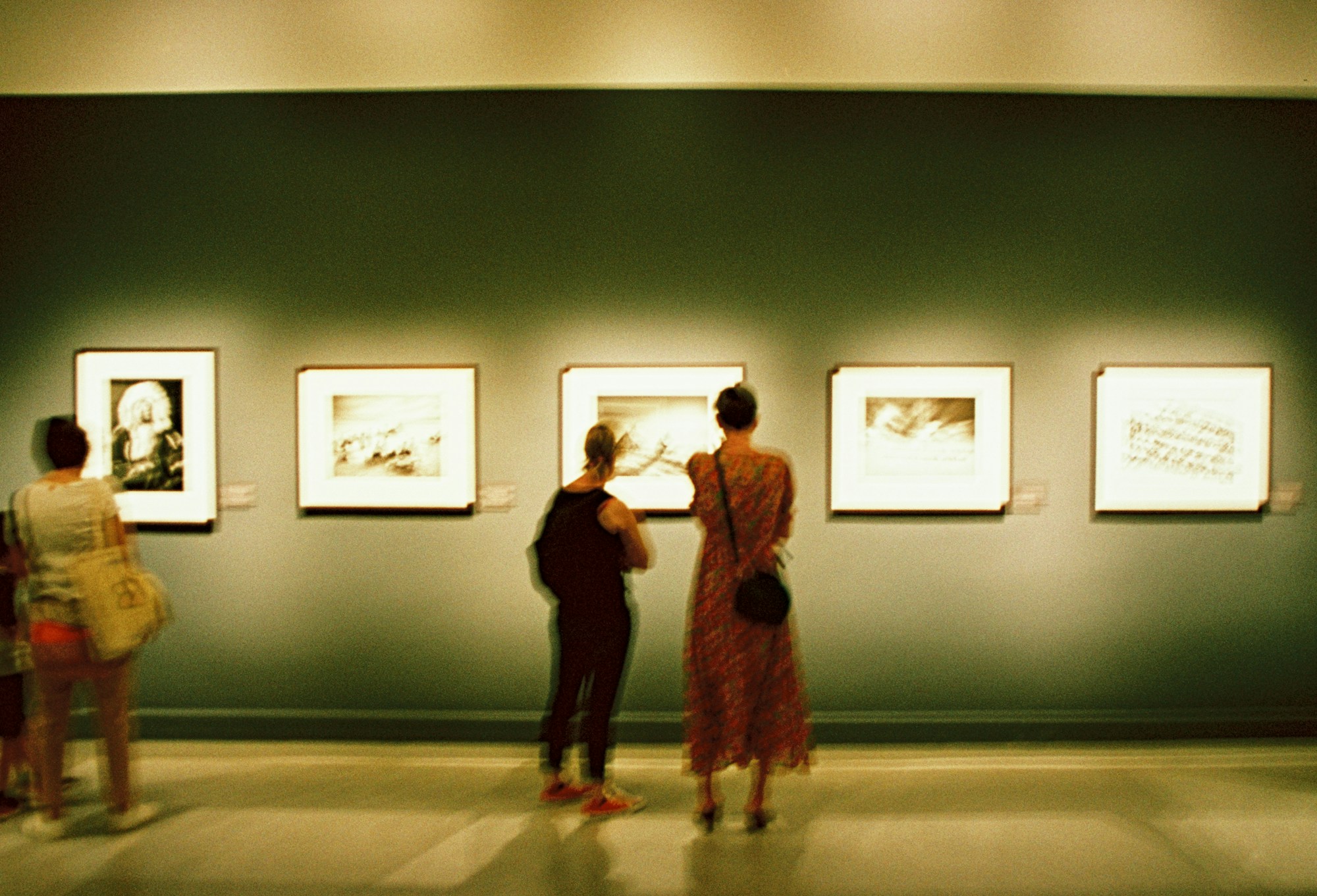 Visitors in front of photographs displayed in a contemporary art gallery