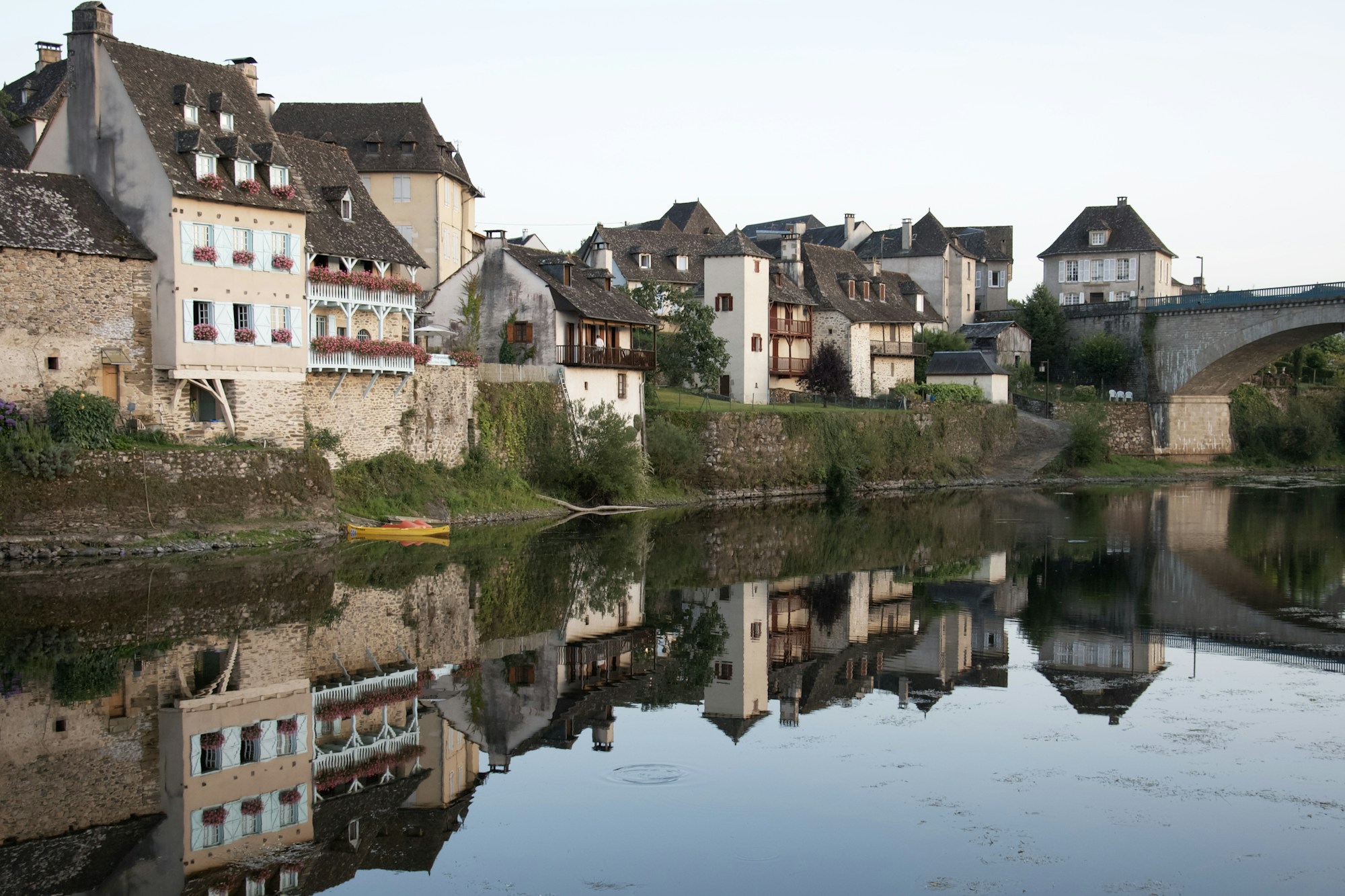 Picturesque small French village with a river and stone bridge