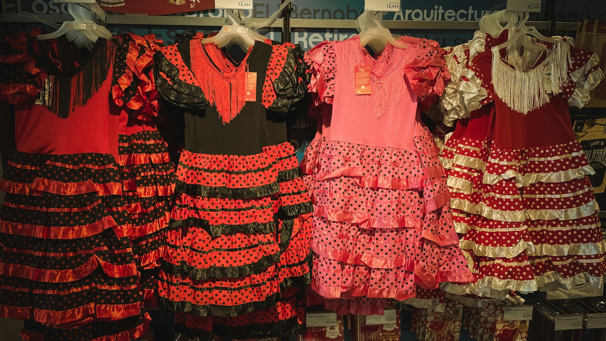 Robes de flamenca colorées sur des portants dans une boutique de Séville