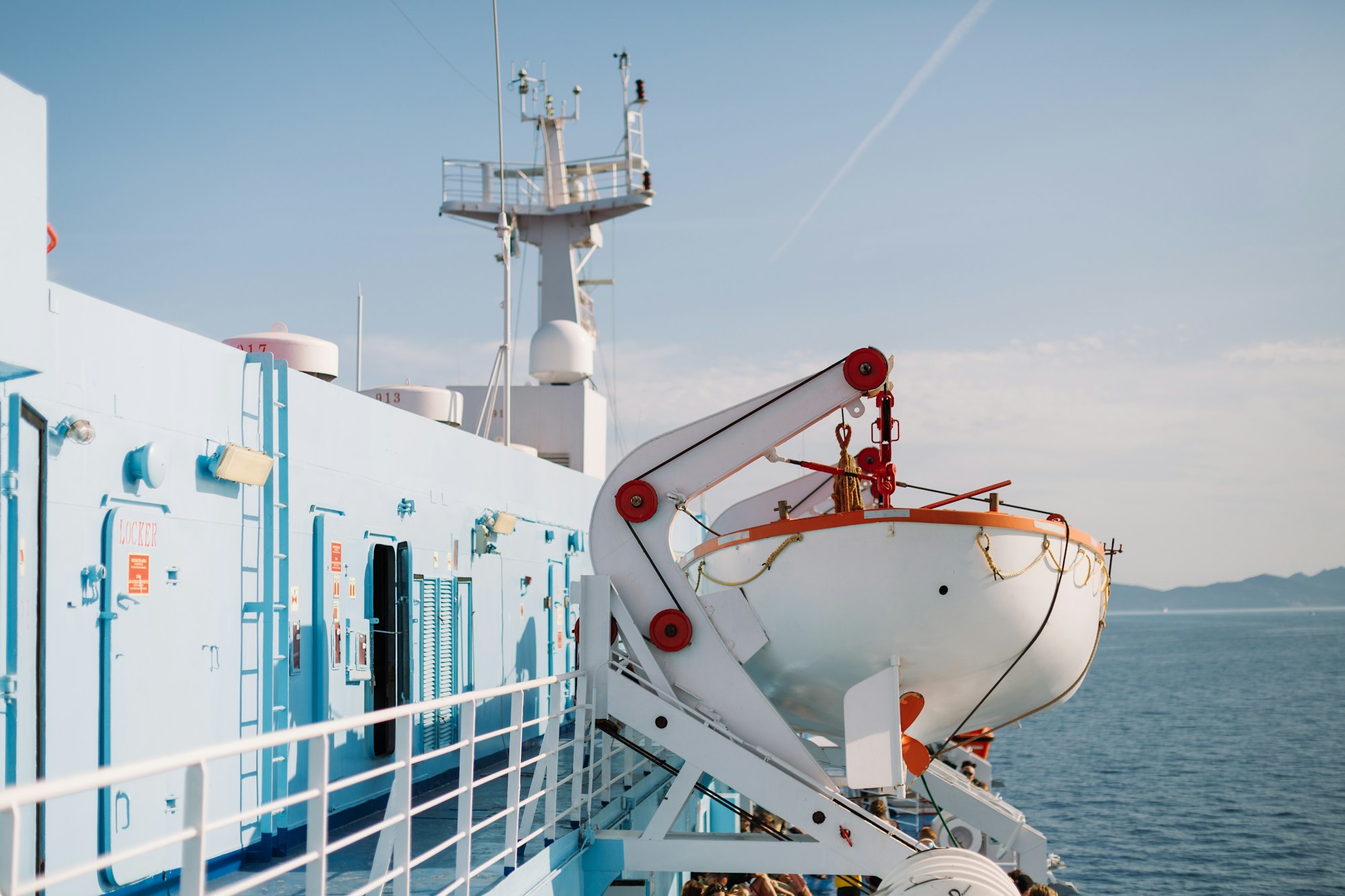 Large white ferry sailing across the Mediterranean under a blue sky