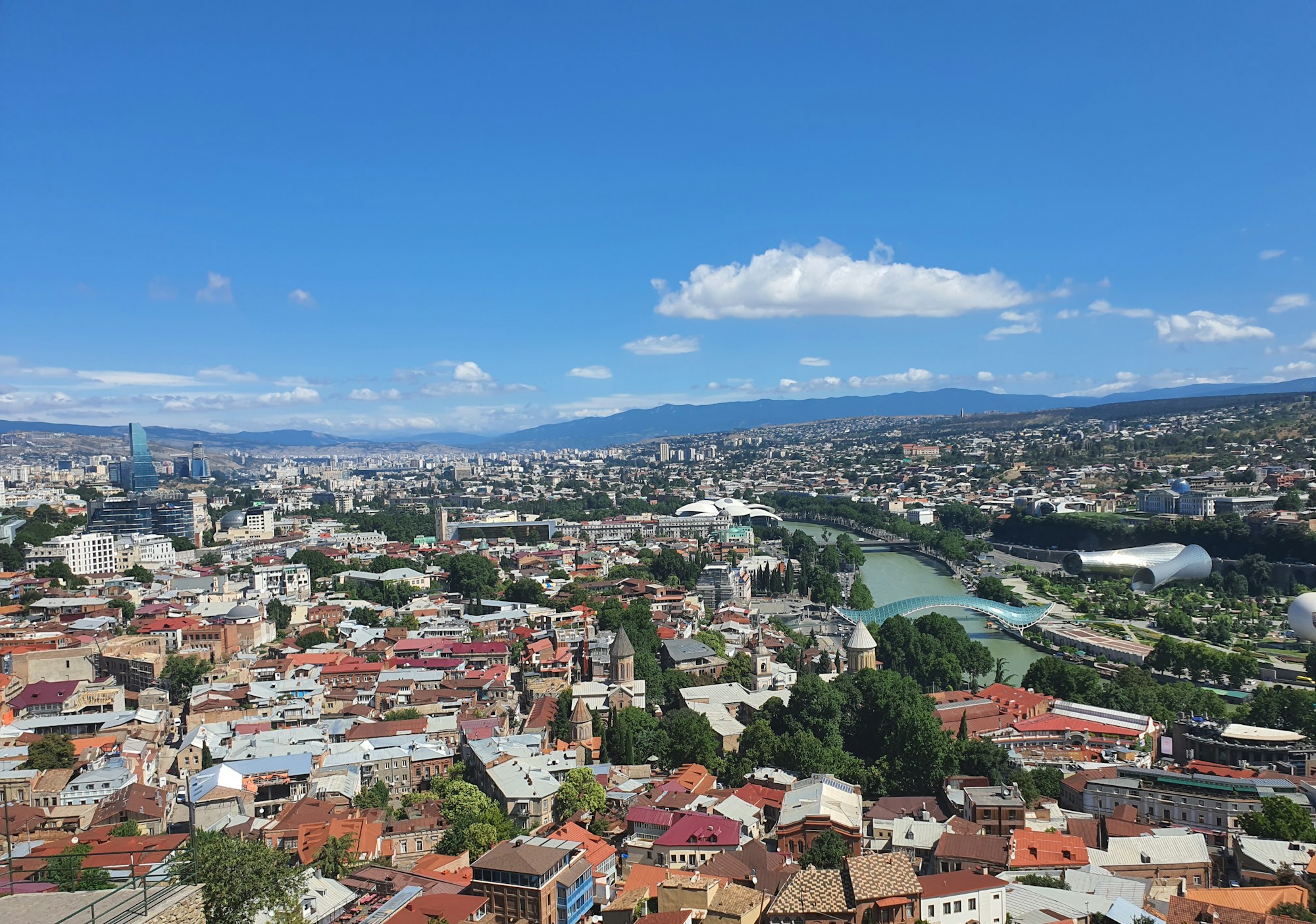 Vue panoramique de Tbilissi depuis la forteresse de Narikala, avec les toits rouges du vieux quartier et les collines boisées en arrière-plan