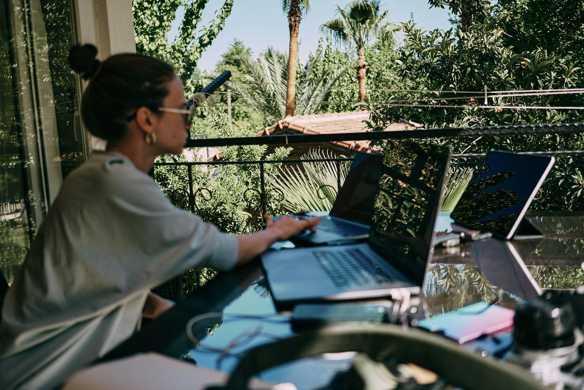 Personne travaillant sur un ordinateur portable en terrasse avec vue, télétravail en house sitting