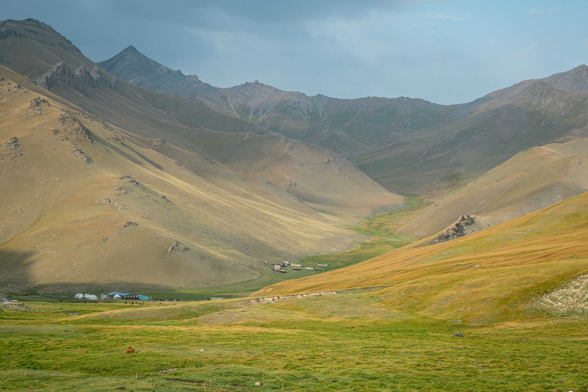 Village kirghiz niché dans une vaste vallée de montagne