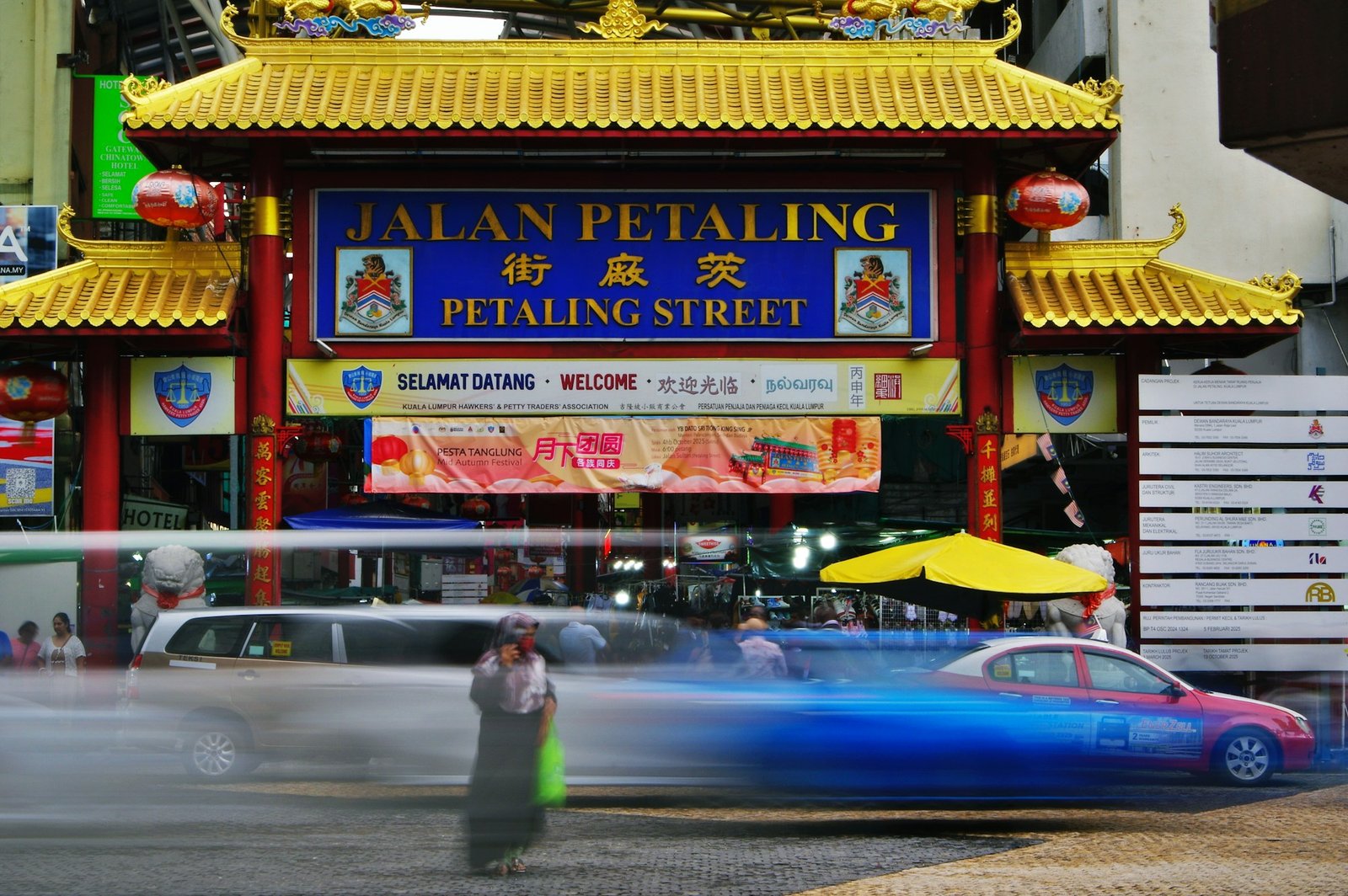 Busy Petaling Street in Kuala Lumpur with a Muslim woman crossing the road