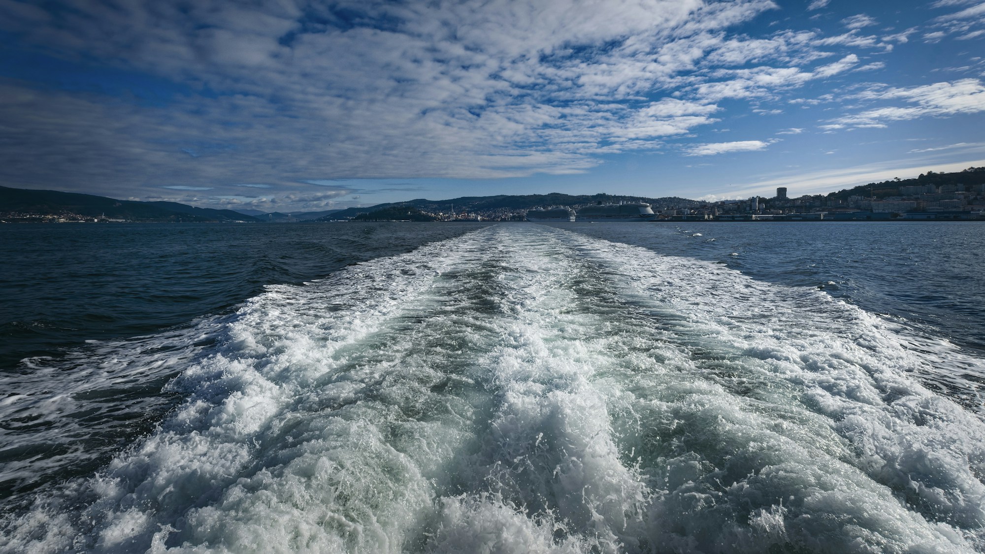 Nave che naviga nel Mar Mediterraneo con una costa sullo sfondo