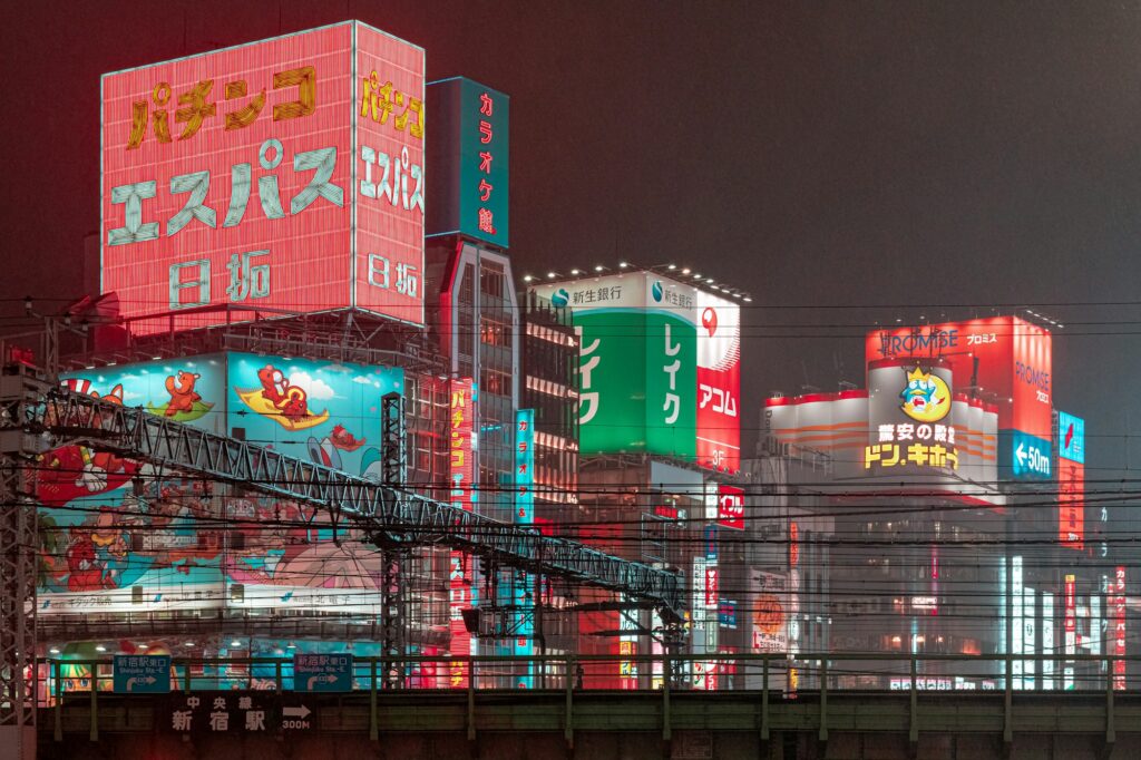 Tokyo la nuit — néons de Shinjuku reflétés sous la pluie, symbole du noctourisme 2026