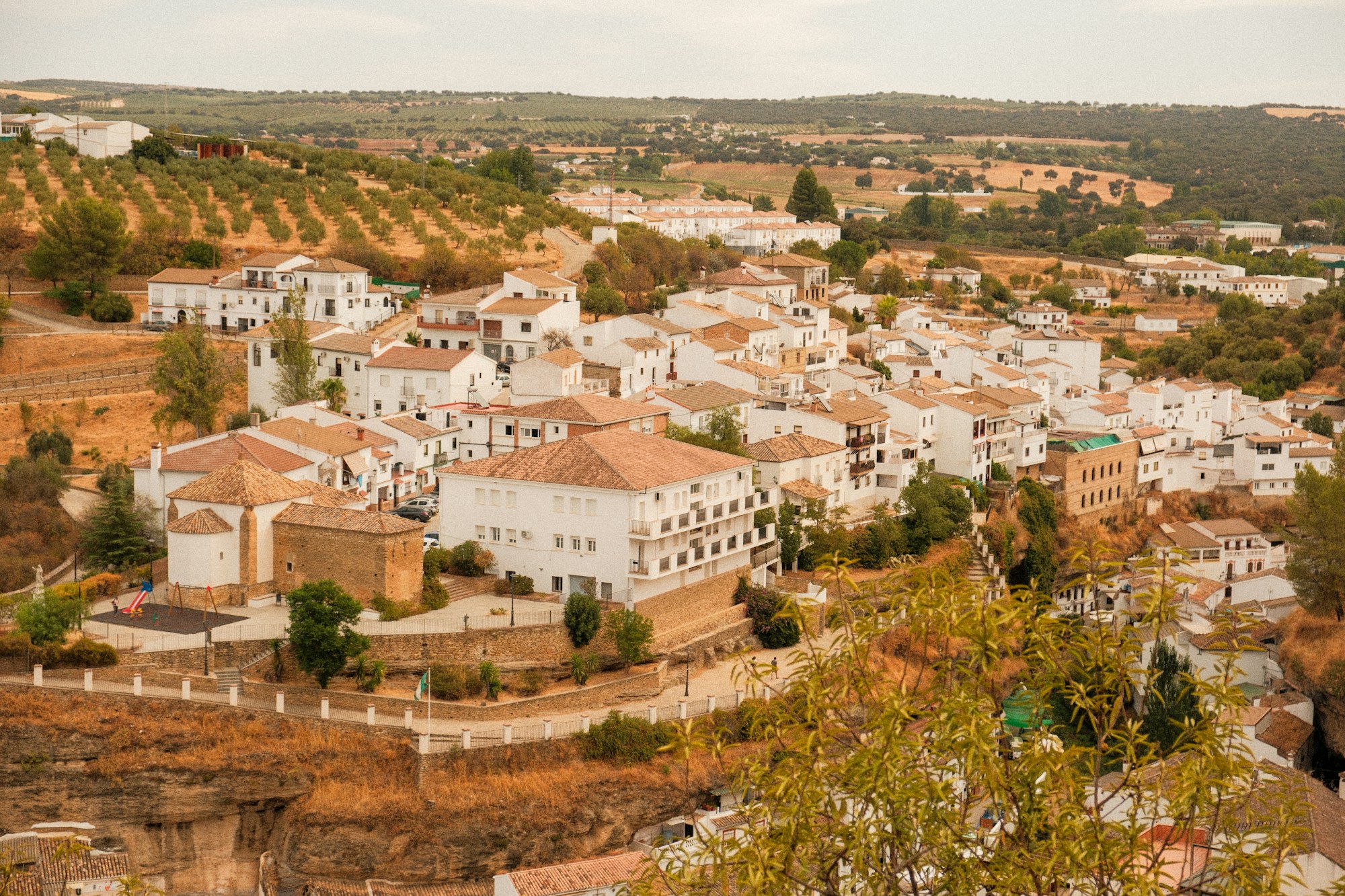 Village blanc niché sur une colline parmi les oliviers en Andalousie