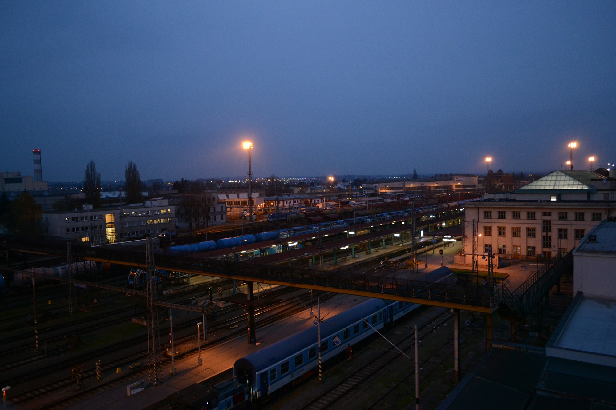 European train station at dusk with a night train ready for departure