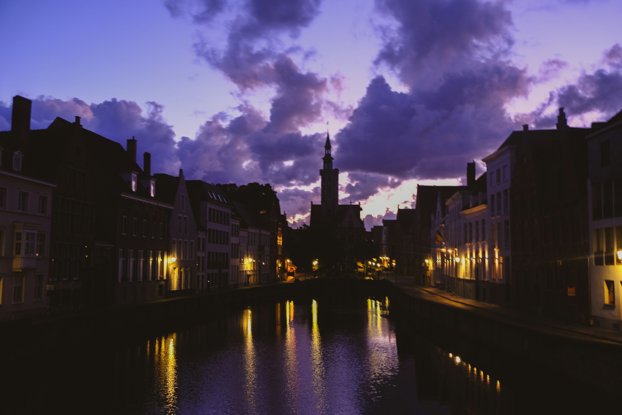 I canali di Bruges fiancheggiati da case medievali in mattoni e salici piangenti in primavera