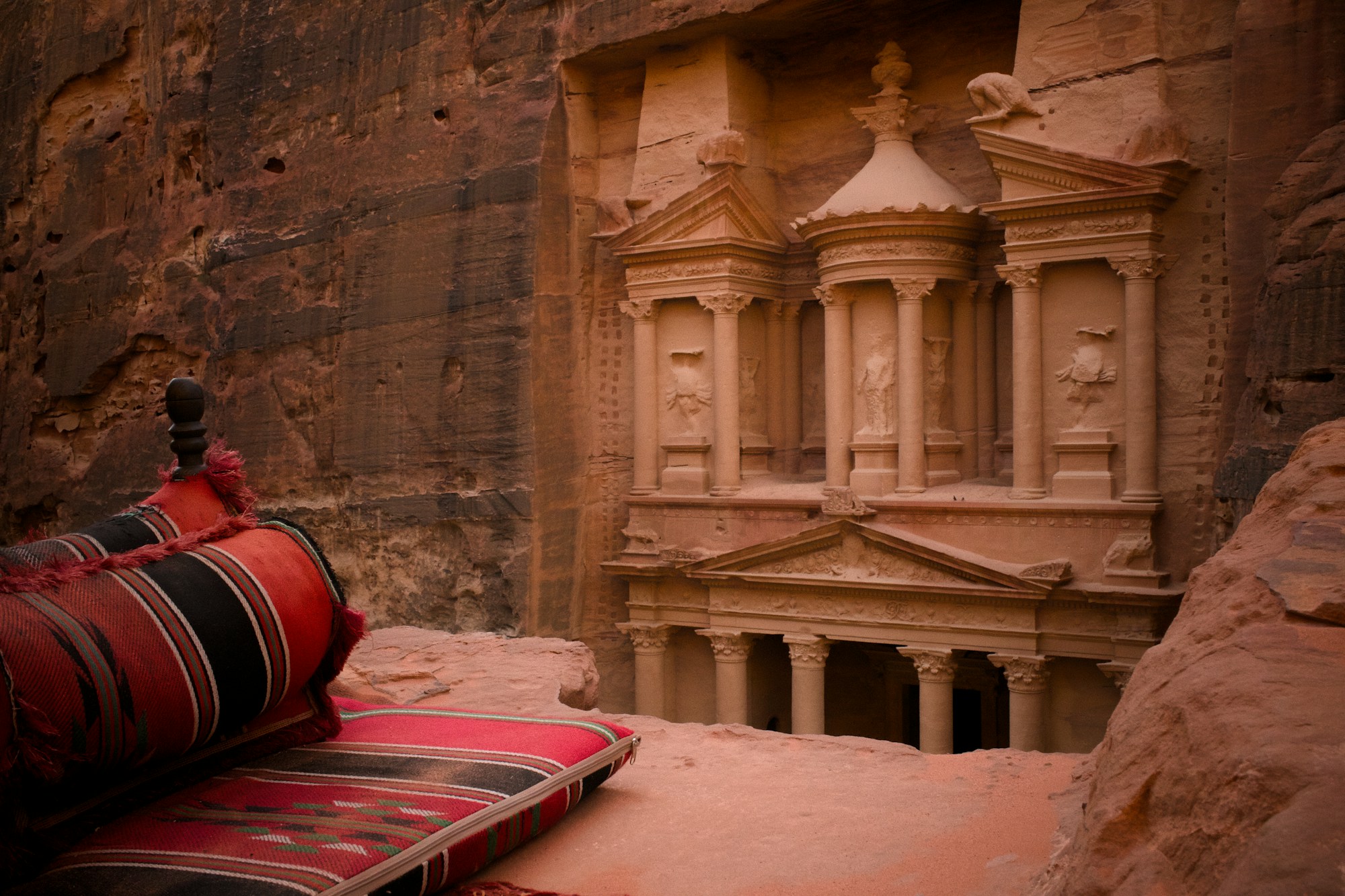 La façade sculptée du Khazneh de Pétra vue de l'intérieur du Siq — cité rose nabatéenne de Jordanie