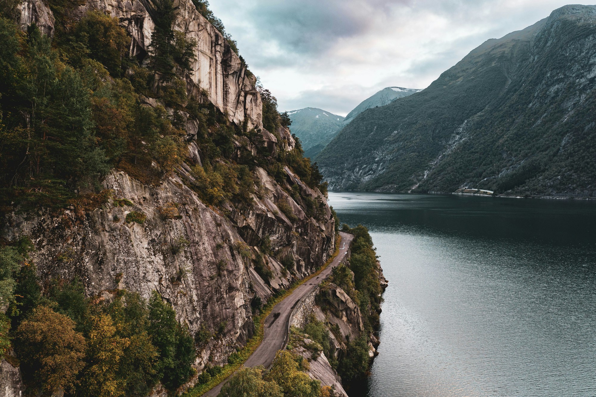 Paysage de fjord norvégien avec montagnes et eaux calmes, itinéraire Oslo-Bergen-Geirangerfjord en voiture électrique
