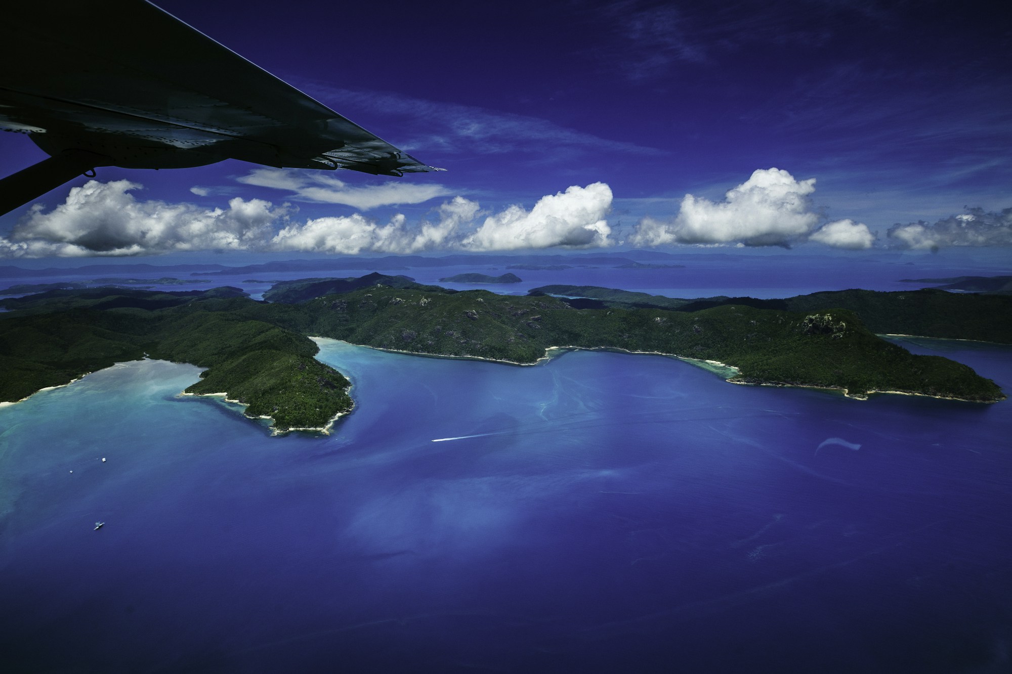 Aerial view of a tropical South Pacific island surrounded by crystal-clear waters