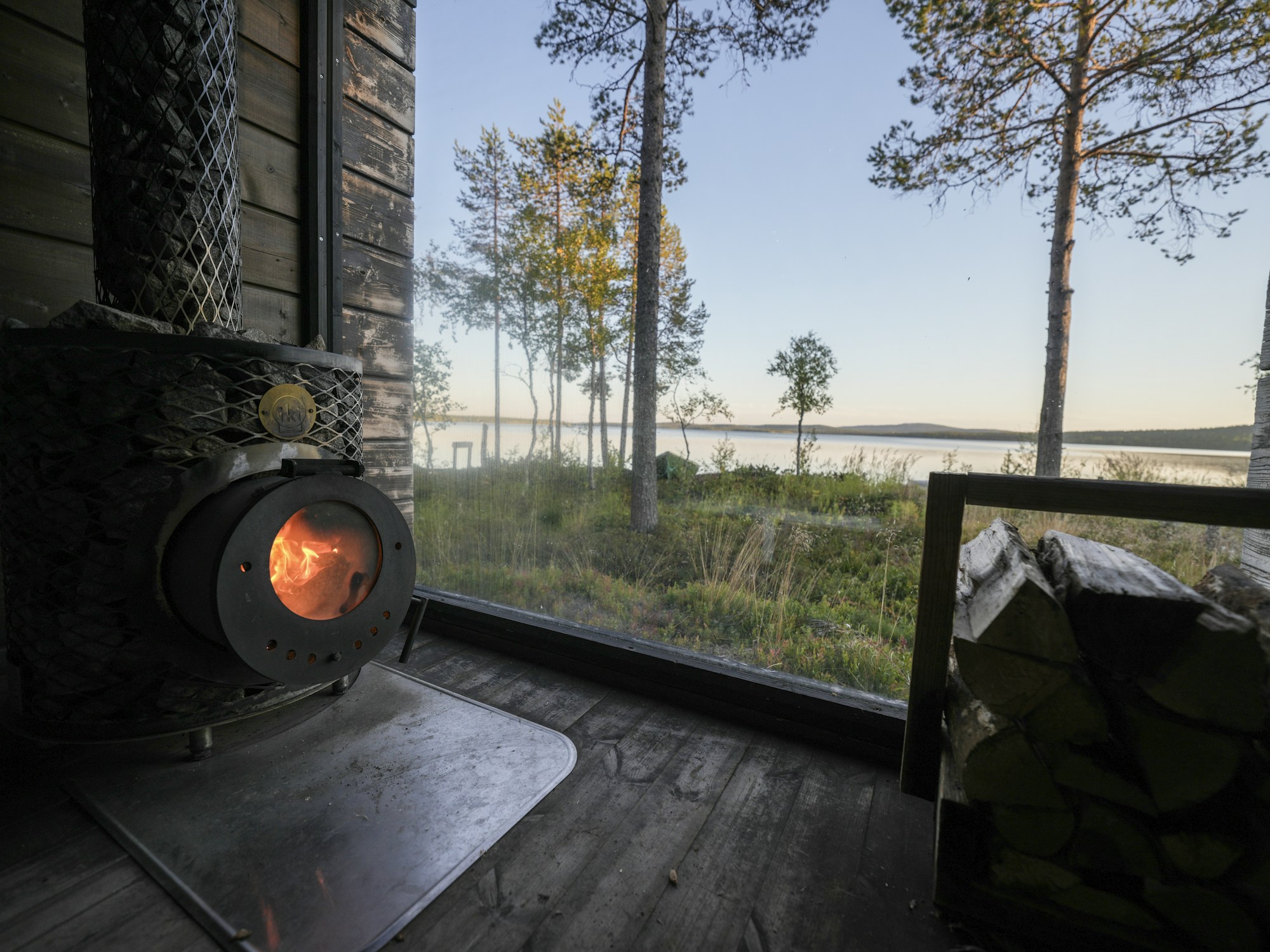 View from inside a Finnish sauna at sunset on the lakeside