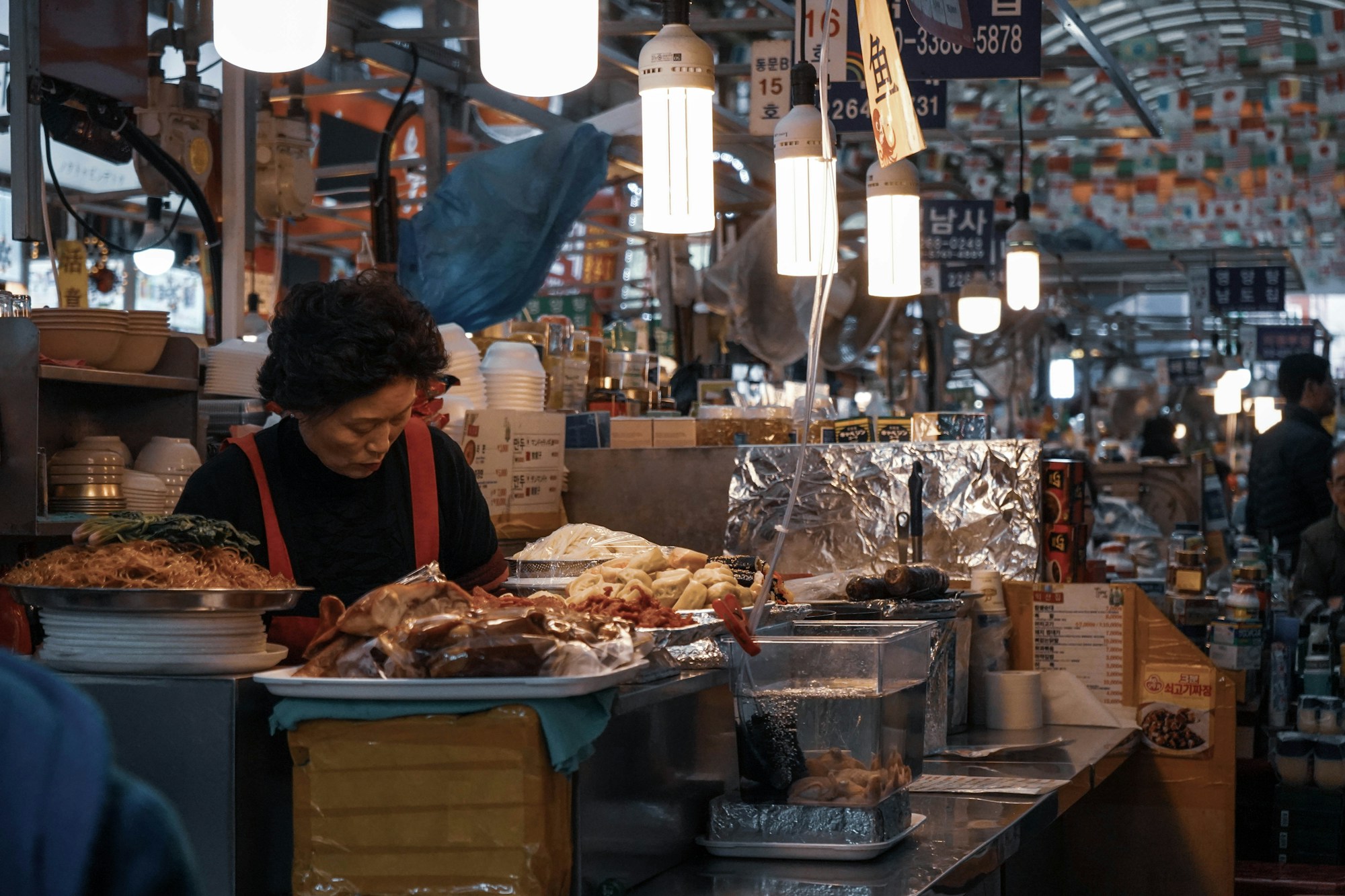Vendedoras en el mercado de Gwangjang en Seúl preparando cocina callejera coreana tradicional