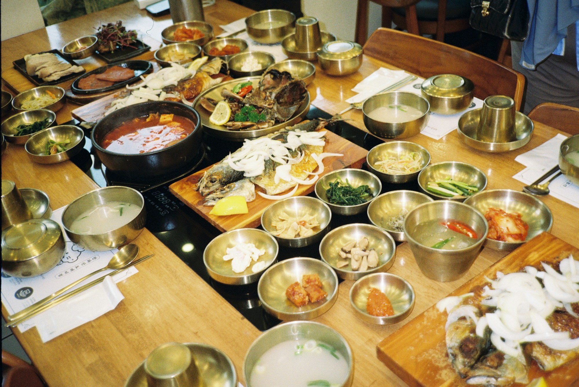 Mesa de gastronomía coreana con banchan, kimchi y platos refinados en un restaurante con estrella Michelin en Seúl
