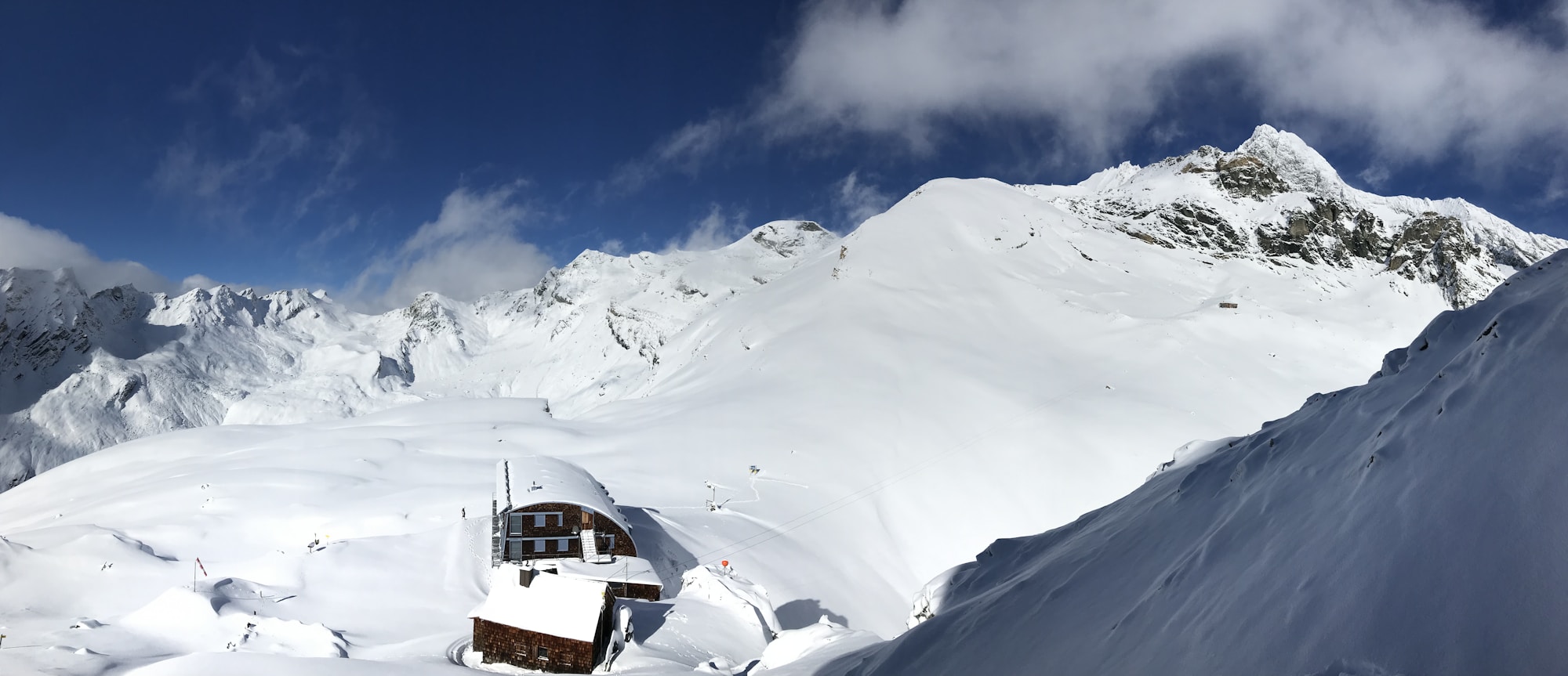 Refuge alpin baigné de soleil dans les hautes Alpes en hiver, étape ski de randonnée hut-to-hut