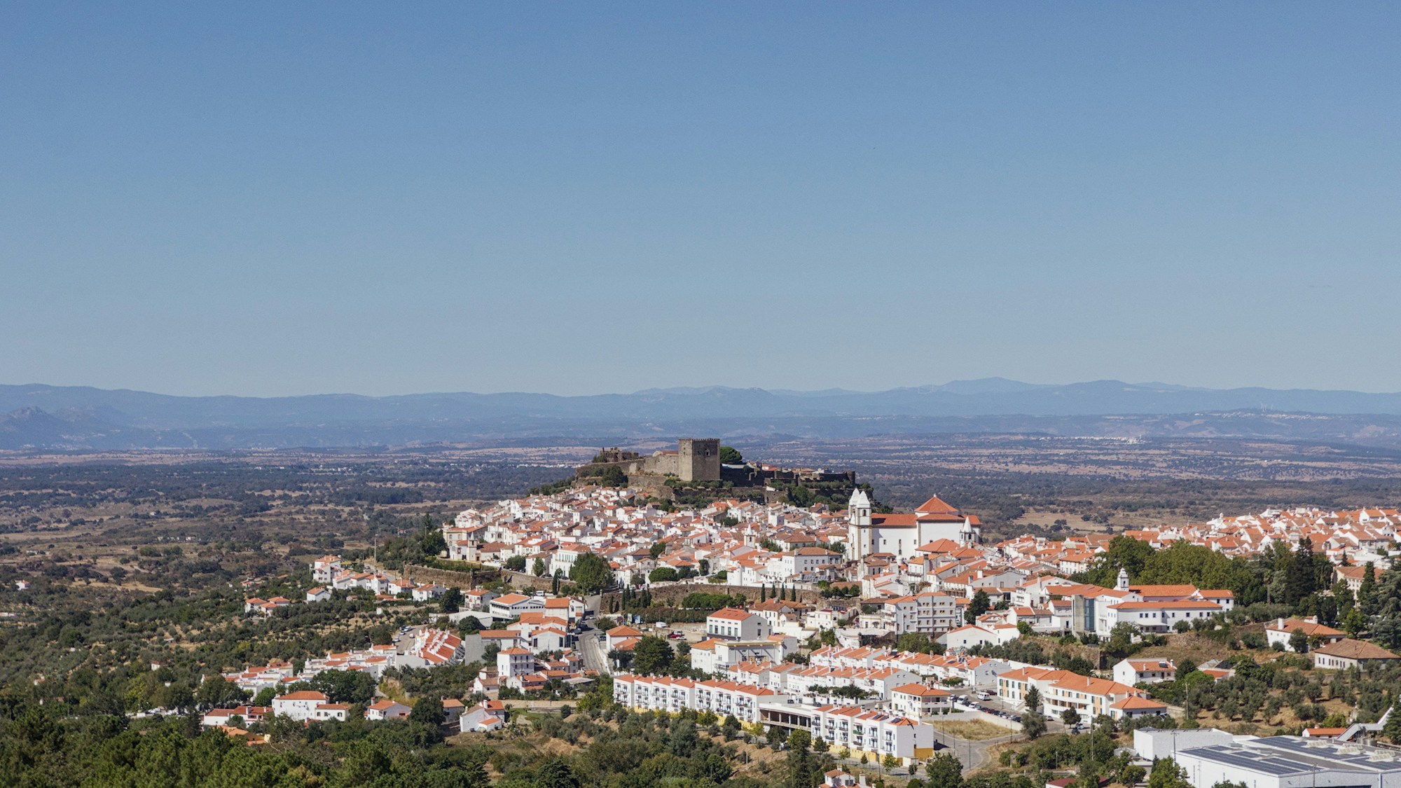 Village médiéval fortifié sur une colline en Alentejo, Portugal, sous un ciel bleu limpide