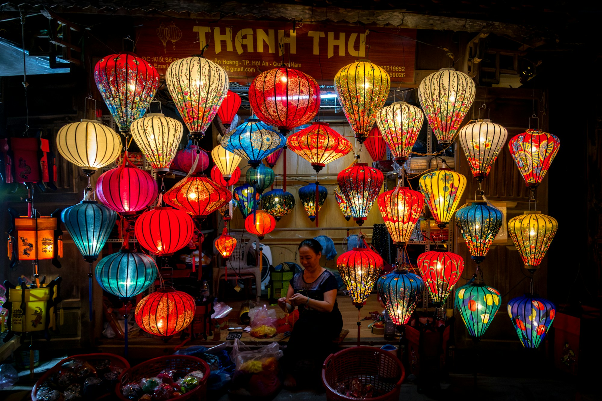Lanternes colorées illuminant le marché nocturne de Hội An au Vietnam, voyageurs se promenant sous les lampions