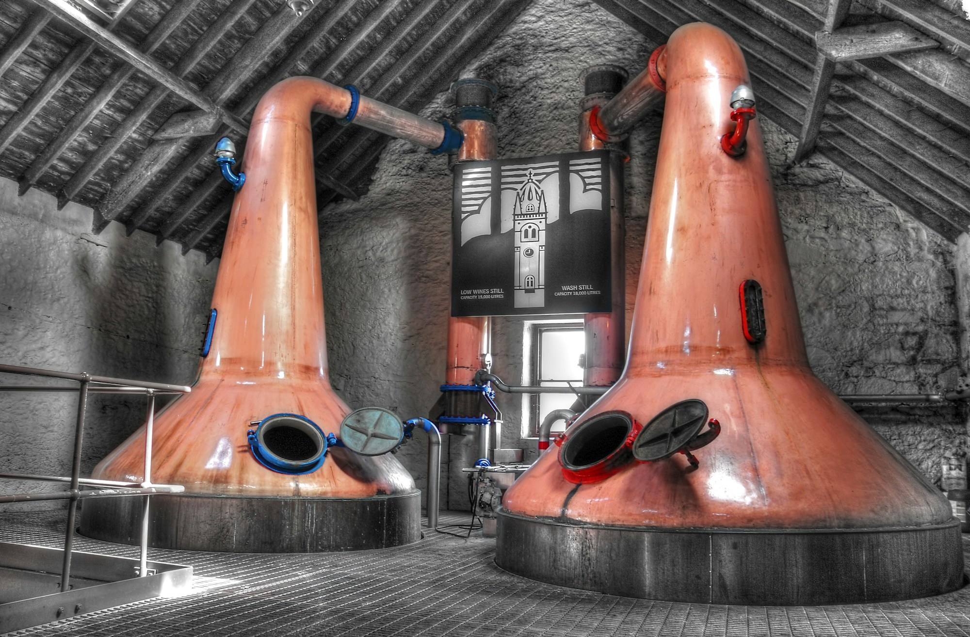 Two copper pot stills in a distillery production room, artisanal distillation equipment