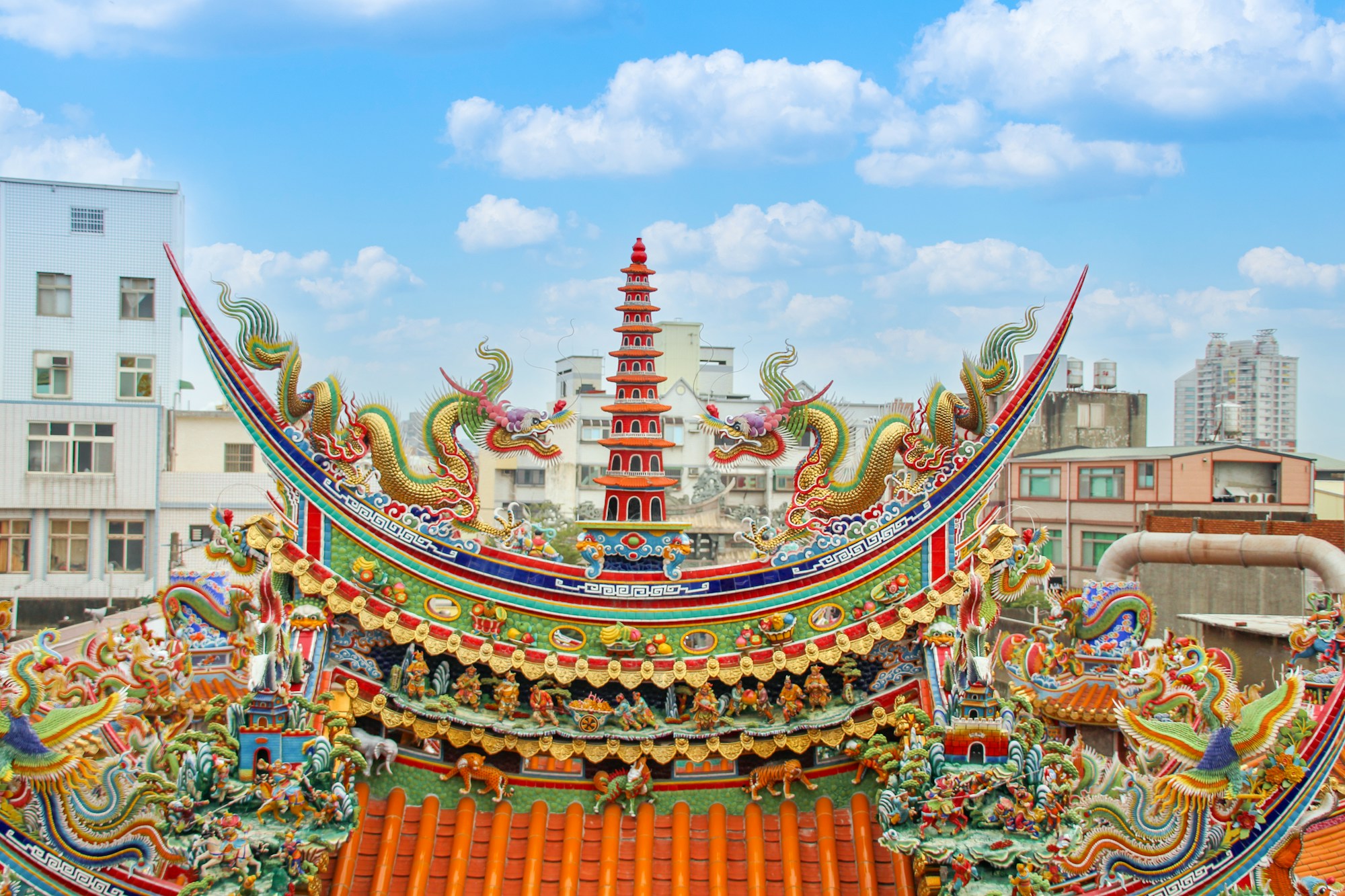 Temple taïwanais avec toit traditionnel orné de dragons sous un ciel bleu à Taiwan