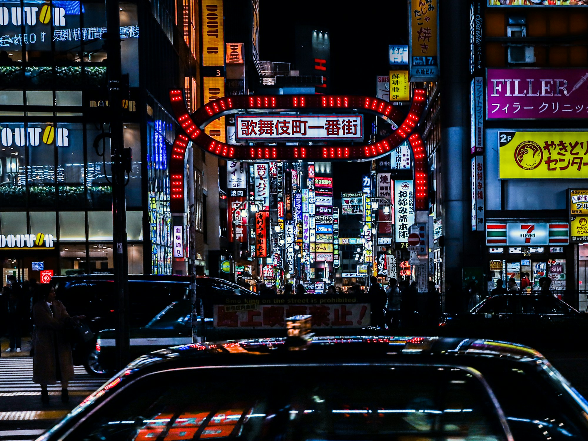 Promenade nocturne dans les rues néon de Shinjuku, Tokyo, reflets sur le sol mouillé