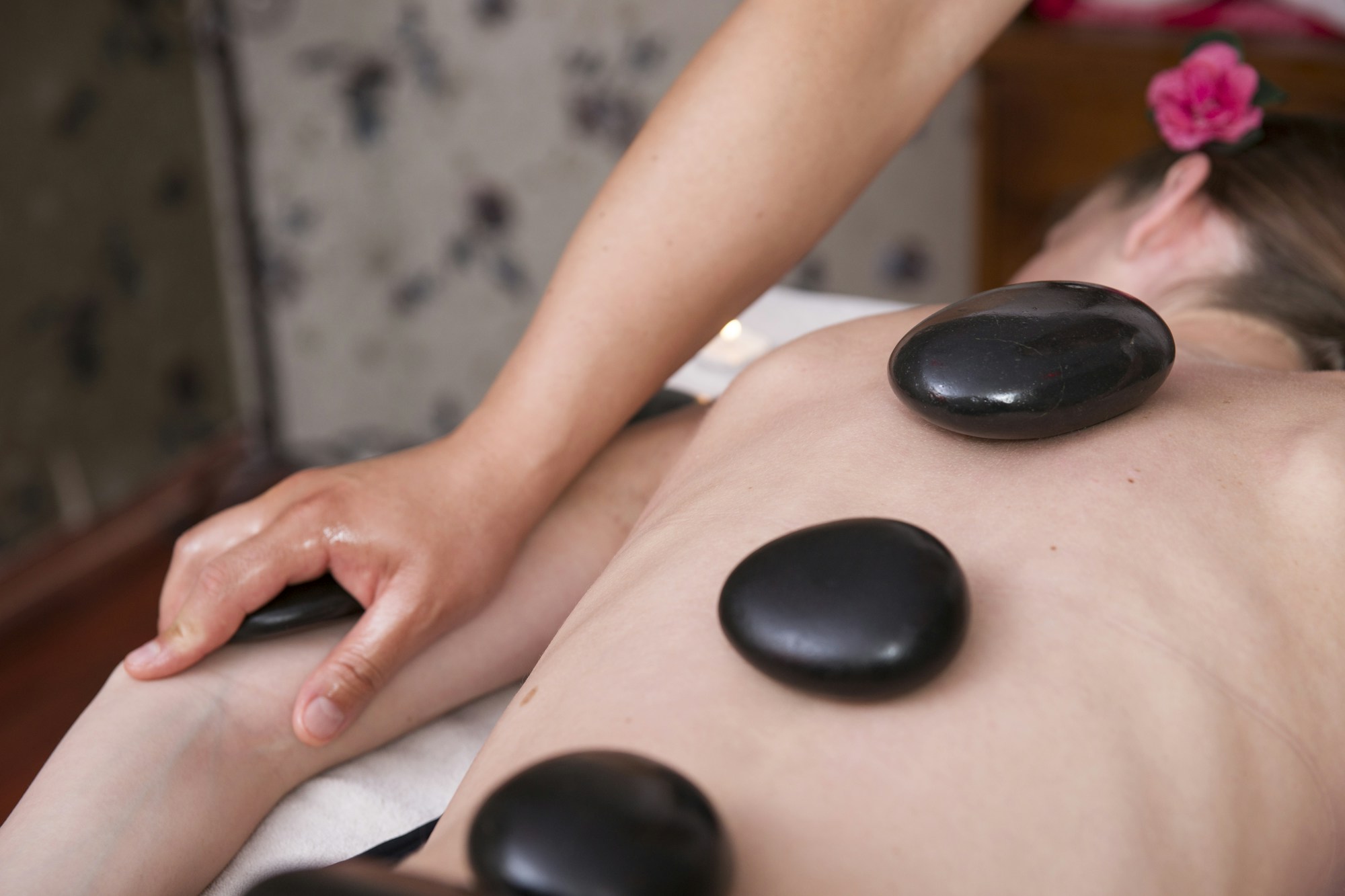 Hot stone massage in a Thai spa, the nuad thai tradition inscribed on the UNESCO heritage list