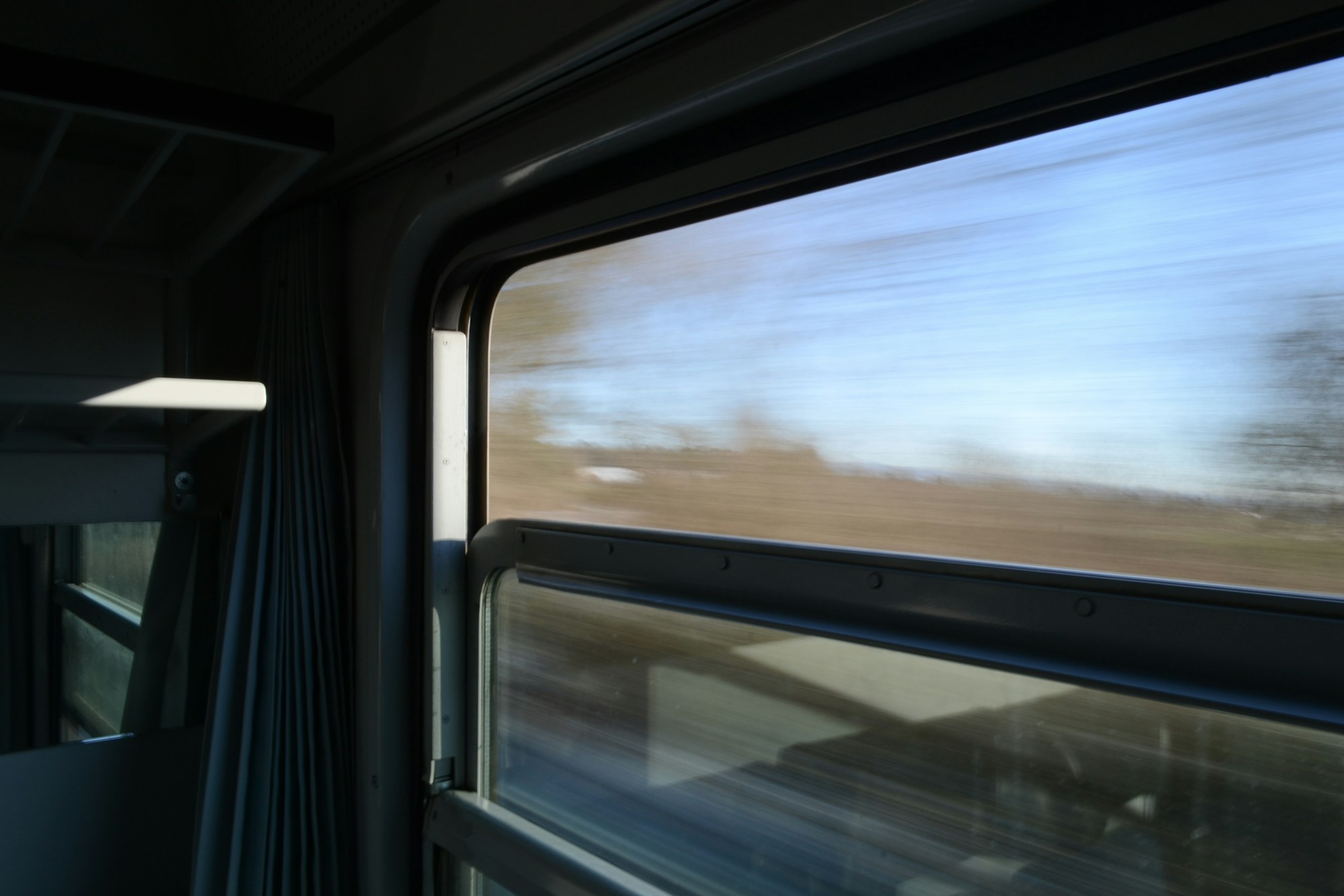 Vue depuis la fenêtre d'un train en mouvement sur un paysage européen, alternative à la ligne annulée Basel-Malmö