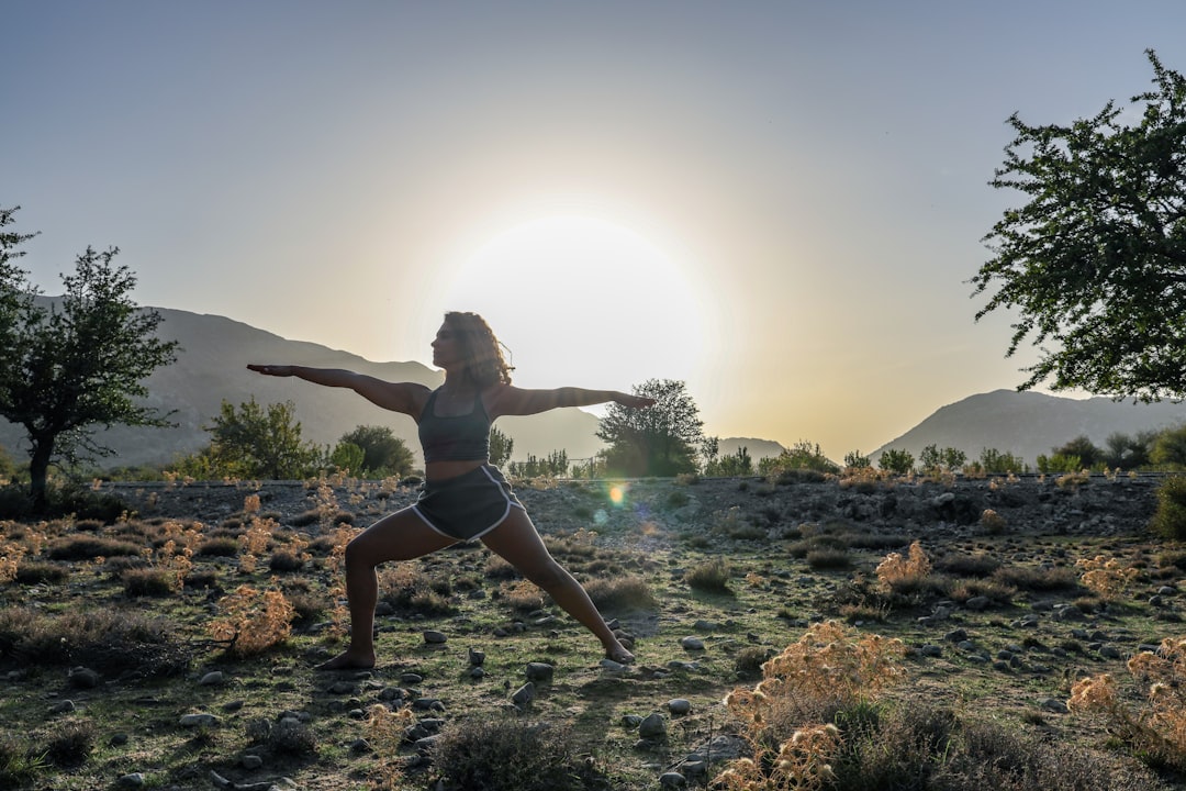 Séance de yoga en plein air dans un cadre naturel, pratiquante en posture face au paysage