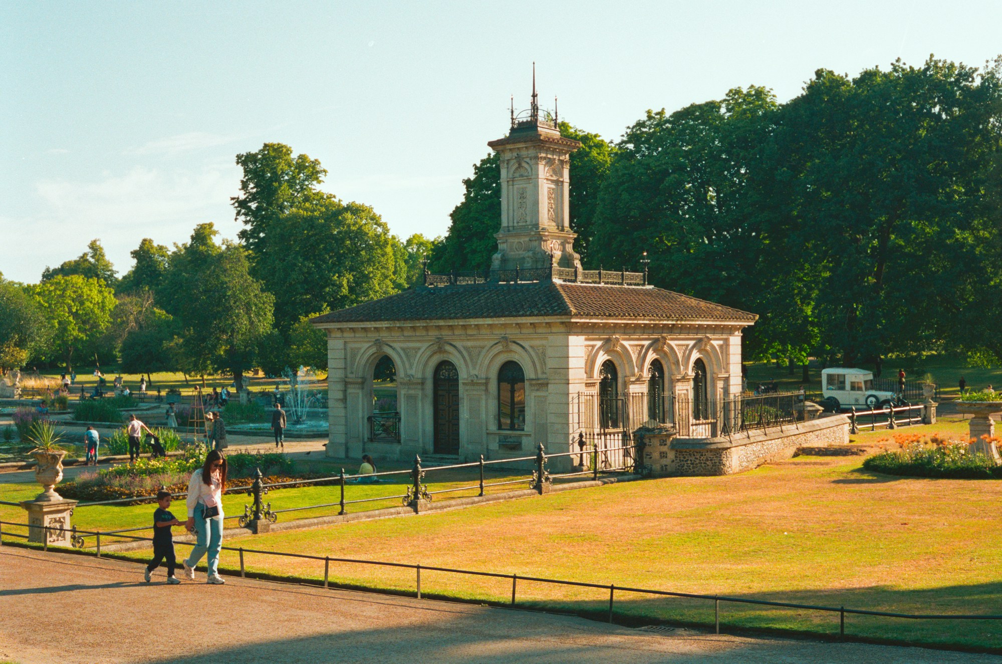 Hyde Park in London bathed in golden summer light, majestic trees and green lawns