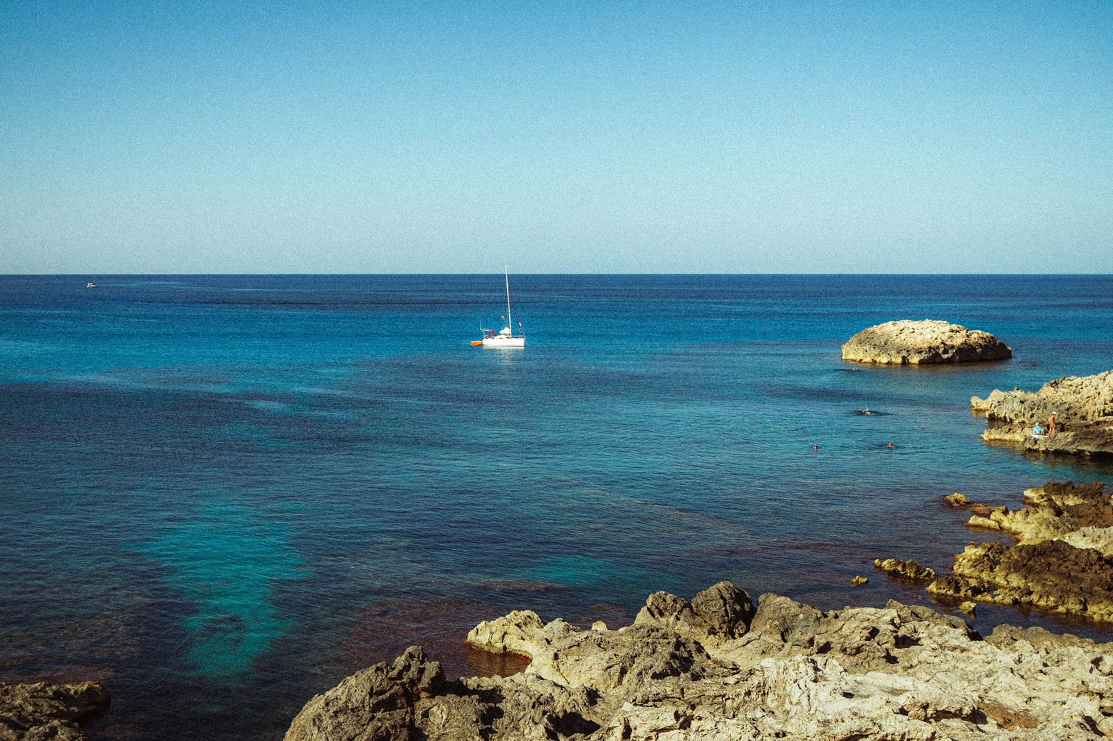 Voilier solitaire sur la mer turquoise de Majorque sous un ciel estival