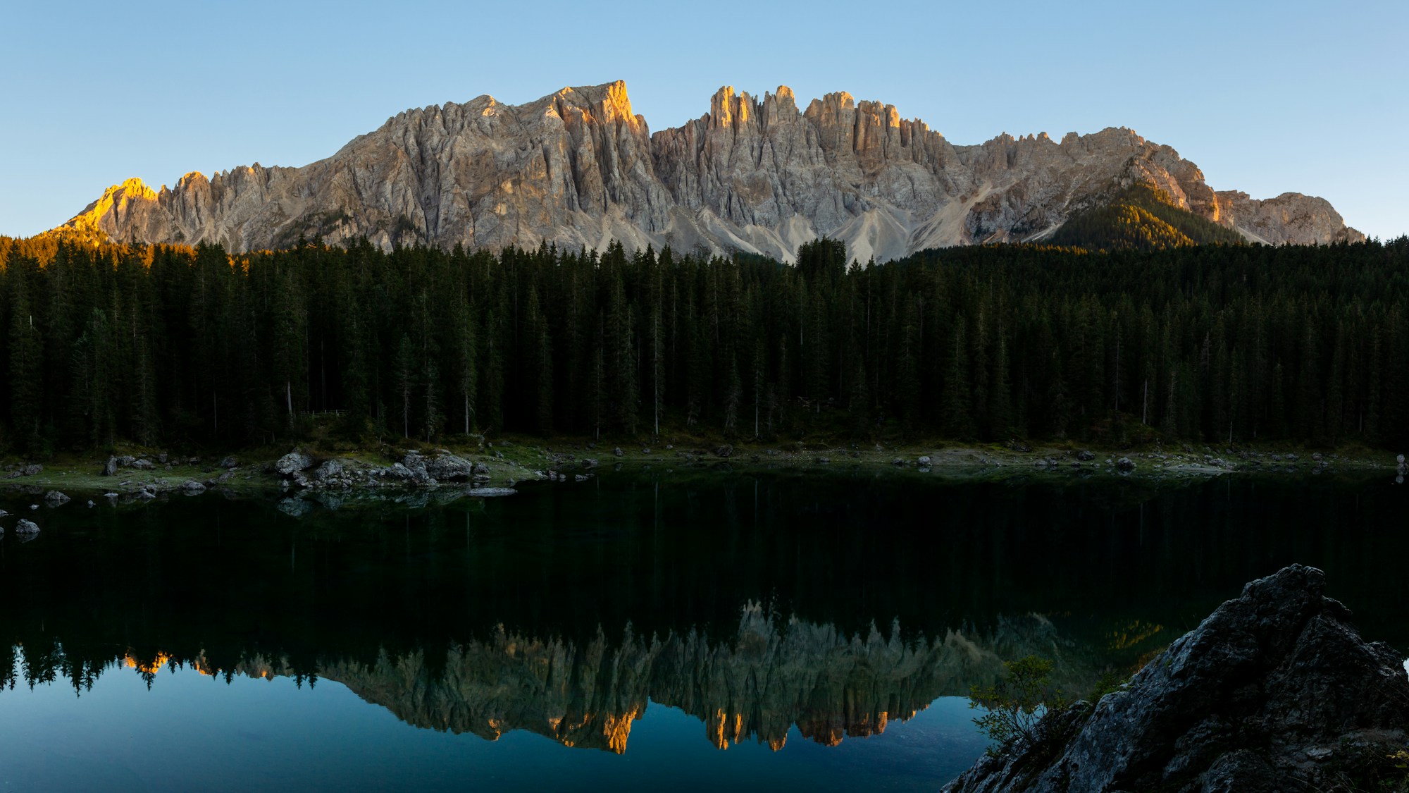 Forêt de pins et lac émeraude dans les Dolomites, Italie — région des étapes finales du Giro 2026