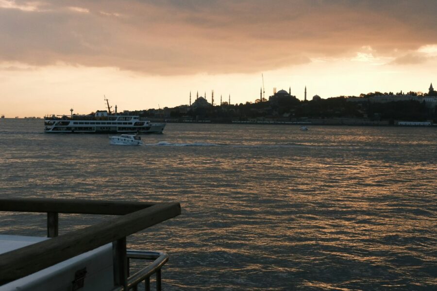 Coucher de soleil doré sur le Bosphore avec la skyline d'Istanbul et un ferry en premier plan, Turquie