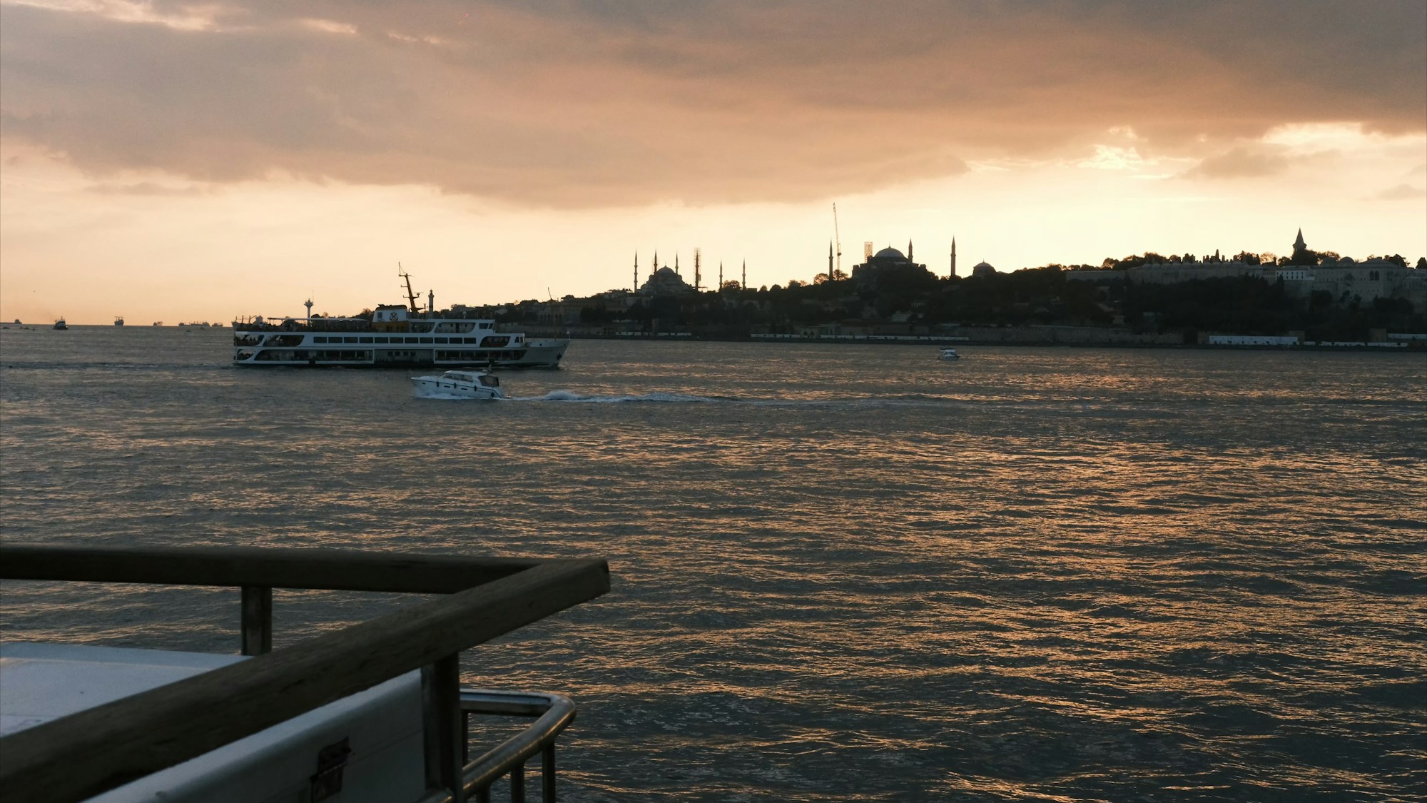 Coucher de soleil doré sur le Bosphore avec la skyline d'Istanbul et un ferry en premier plan, Turquie