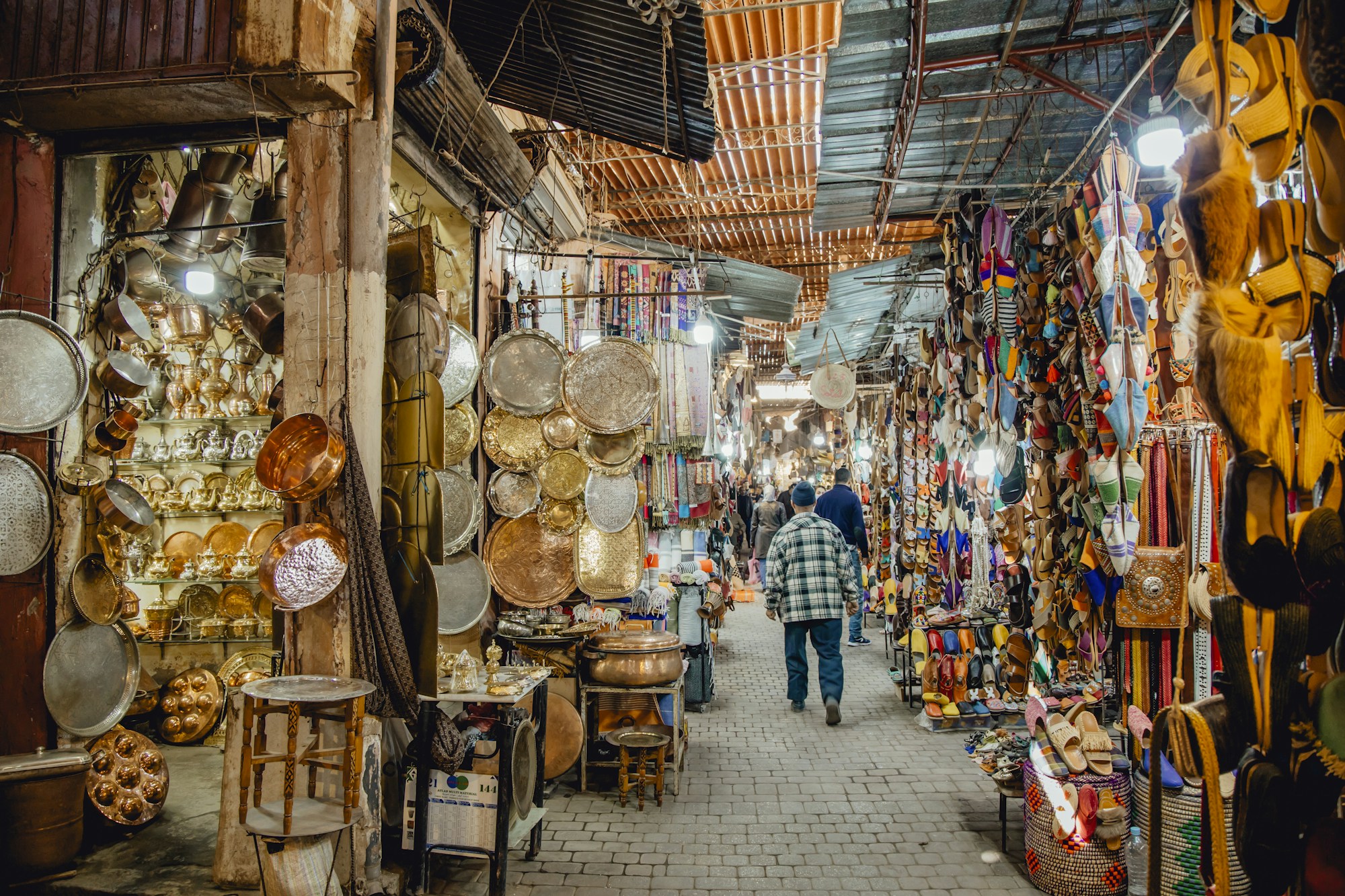 Marché animé de la médina de Marrakech avec marchands et visiteurs entre étals colorés, Maroc