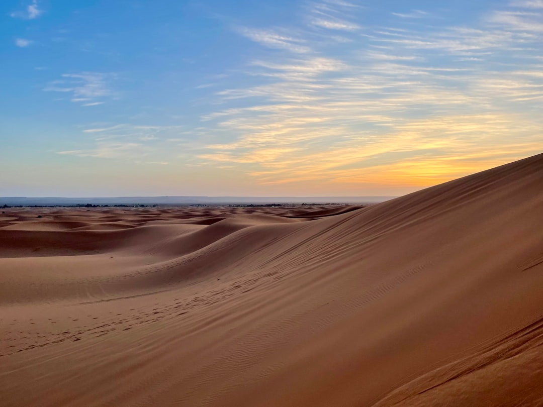Marcheur dans les dunes de sable du désert du Sahara marocain au lever du soleil