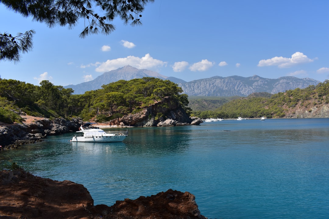 Voilier blanc naviguant sur les eaux turquoise de la côte méditerranéenne de Turquie avec montagnes verdoyantes