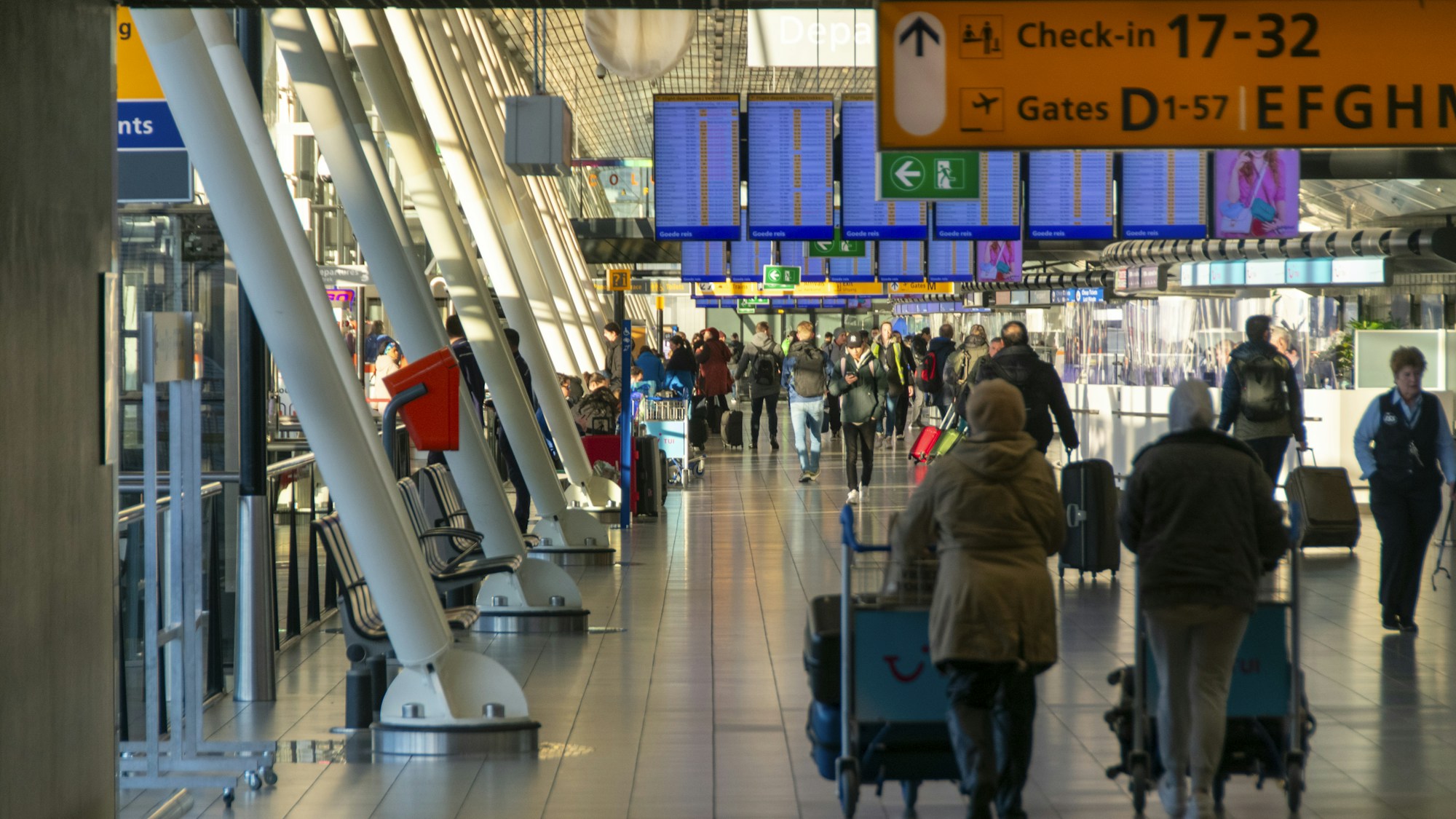 Hall d'enregistrement d'un aéroport international avec voyageurs devant les comptoirs — perturbations vols Proche-Orient 2026