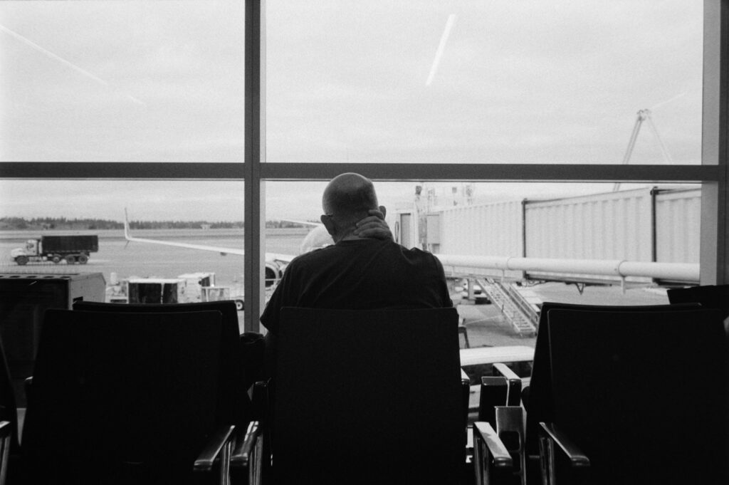 Voyageur pensif dans un salon d'aéroport regardant par la fenêtre