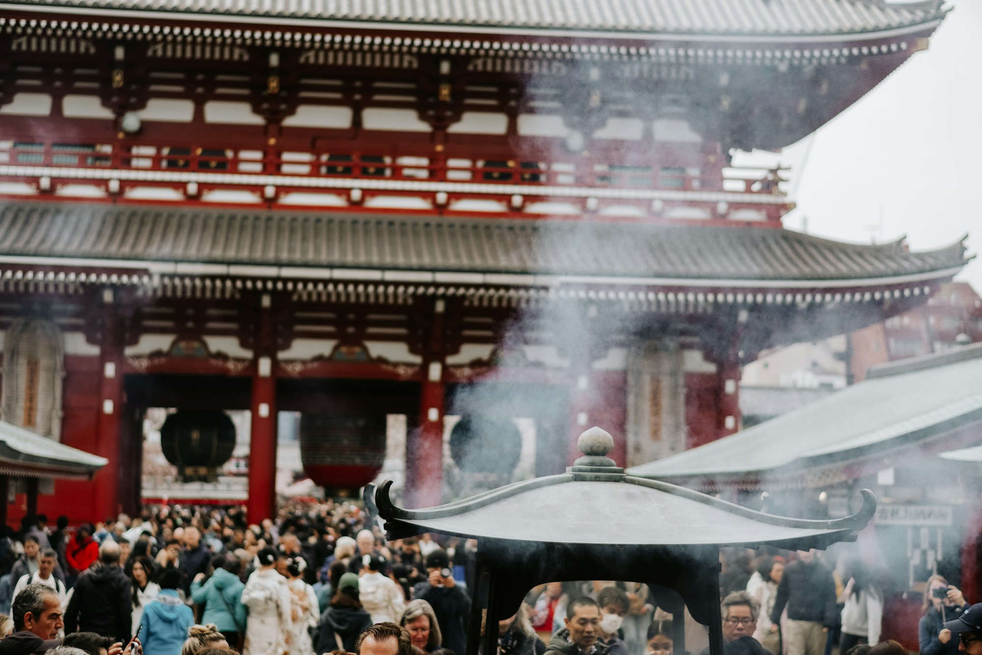 Visitantes reunidos ante un templo japonés tradicional, atmósfera espiritual y tranquila